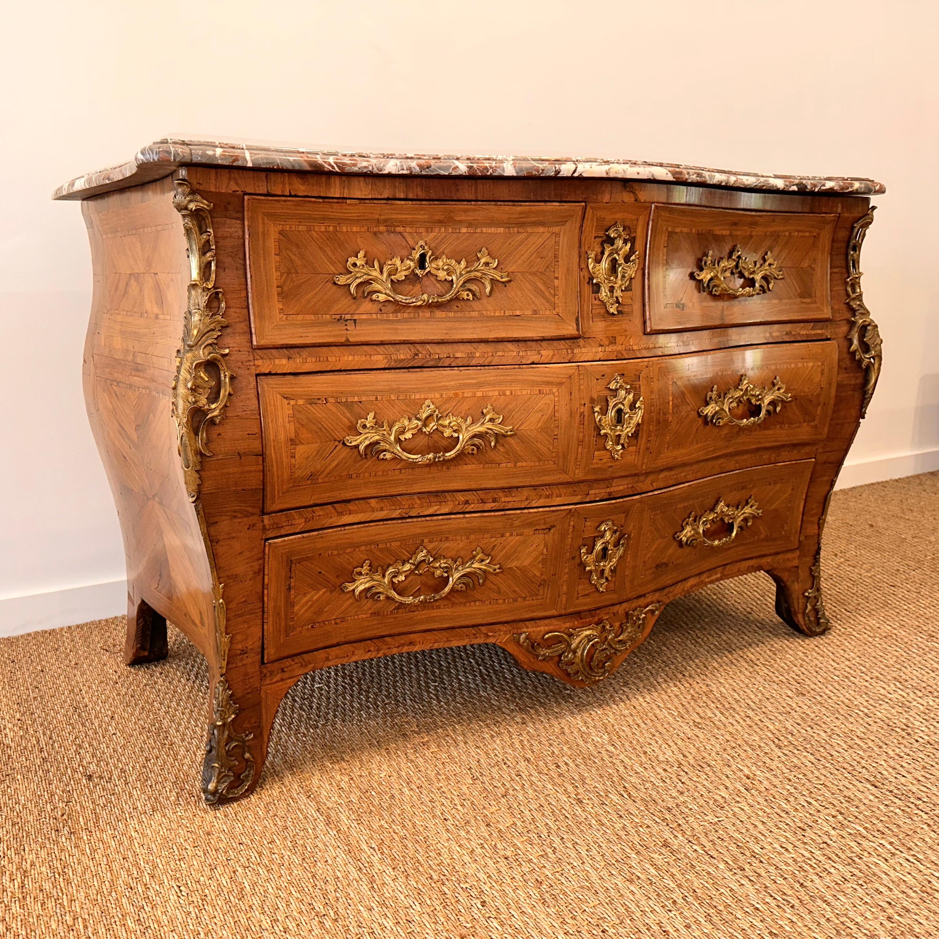 Outstanding example of 18th century Louis XV commode Serpentine Fronted Tombeau Shaped in kingwood veneer, with chased and gilt bronze ornamentation, the front opening with four drawers in three  
rows,  on 
curved legs; Marble top with original