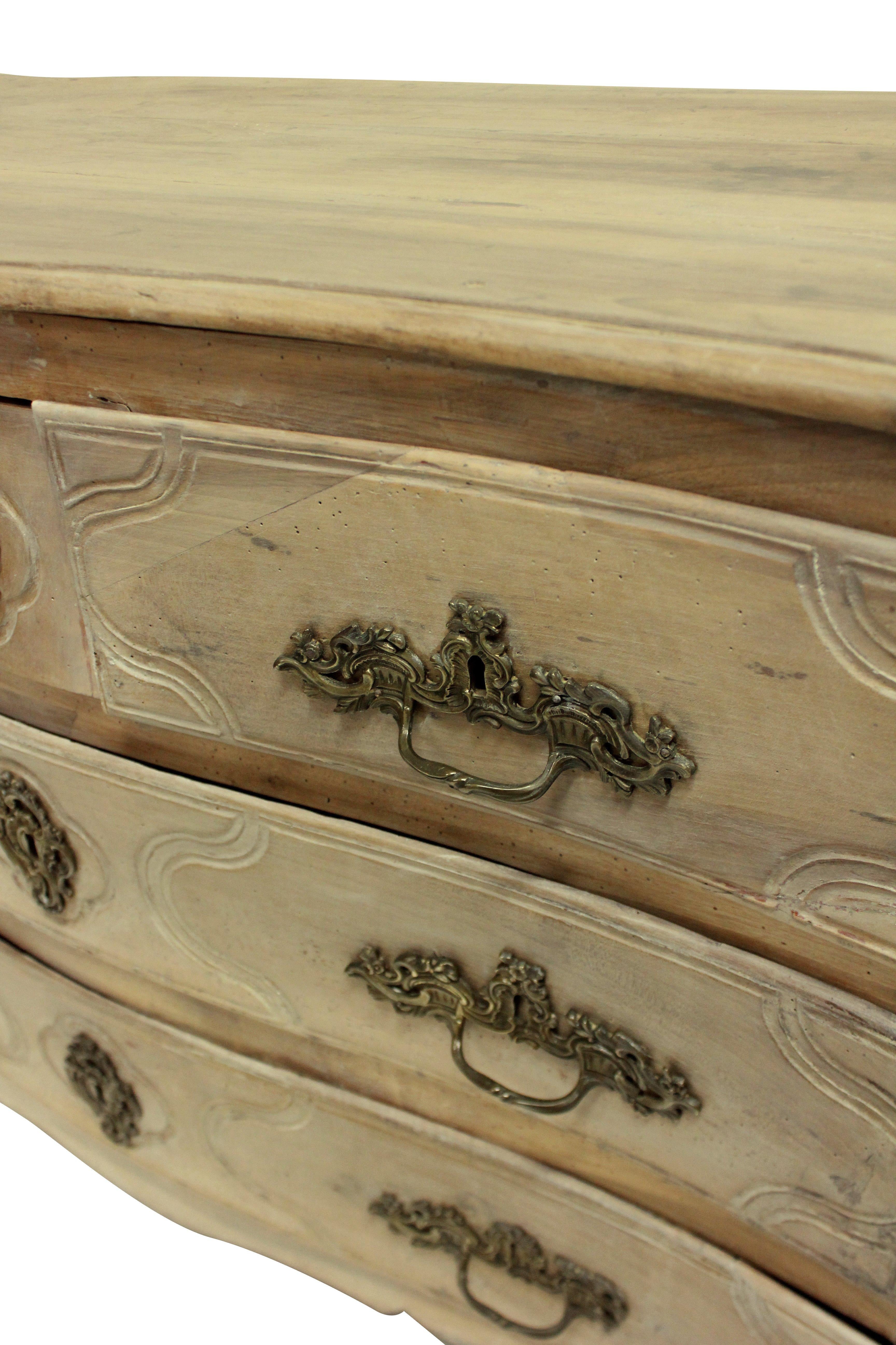 Commode Louis XV du XVIIIe siècle en noyer décapé, avec façade en serpentin et cinq tiroirs. Les poignées originales en bronze. Le décapage était une tendance populaire dans les années 1920-1930.