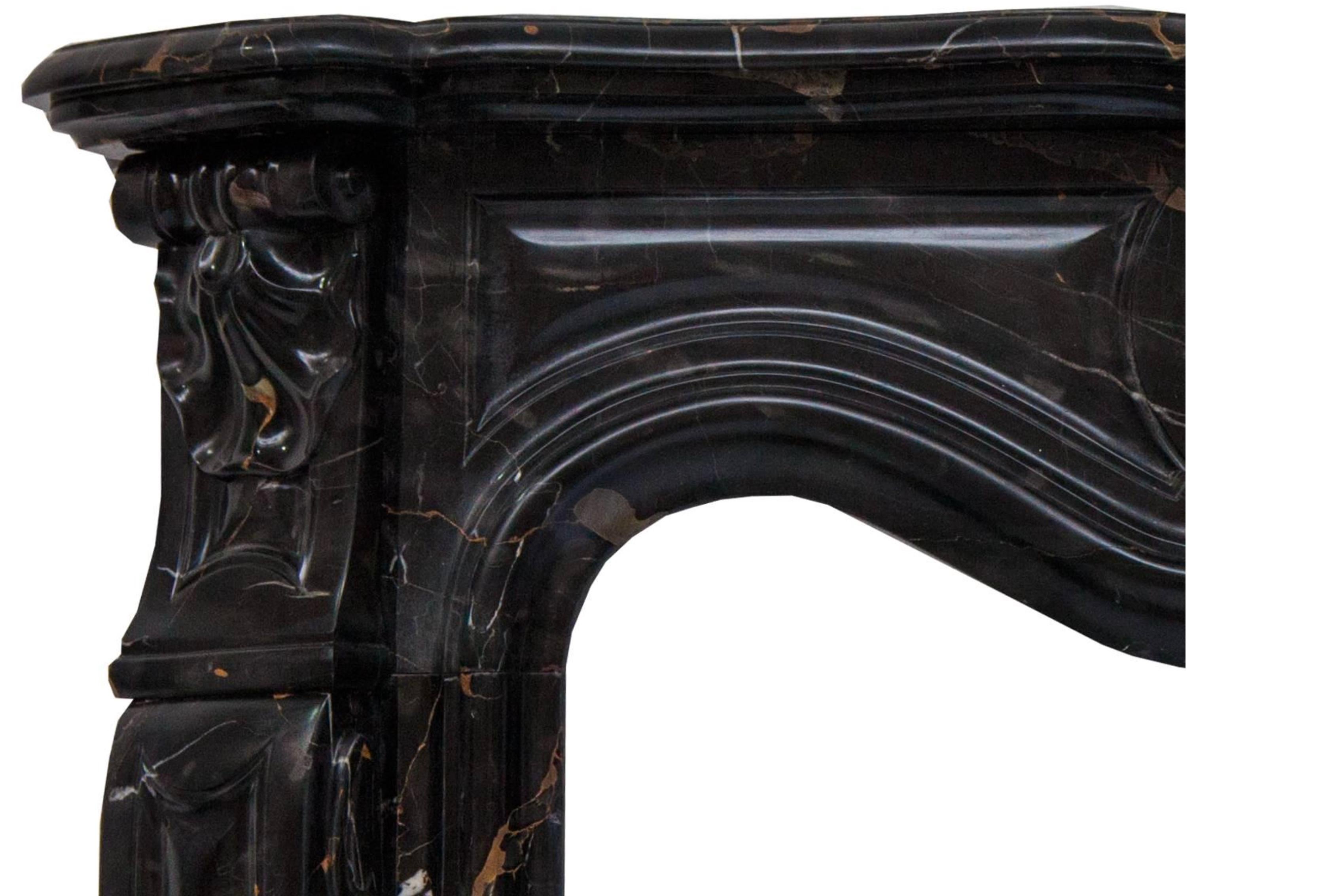 French Rococo Louis XV fireplace mantel made in a superb Potoro marble. Hand carved molded shelf above a paneled frieze, centered by an elaborate scrolled cartouche enclosed on the end blocks set above the angled scrolled jambs.