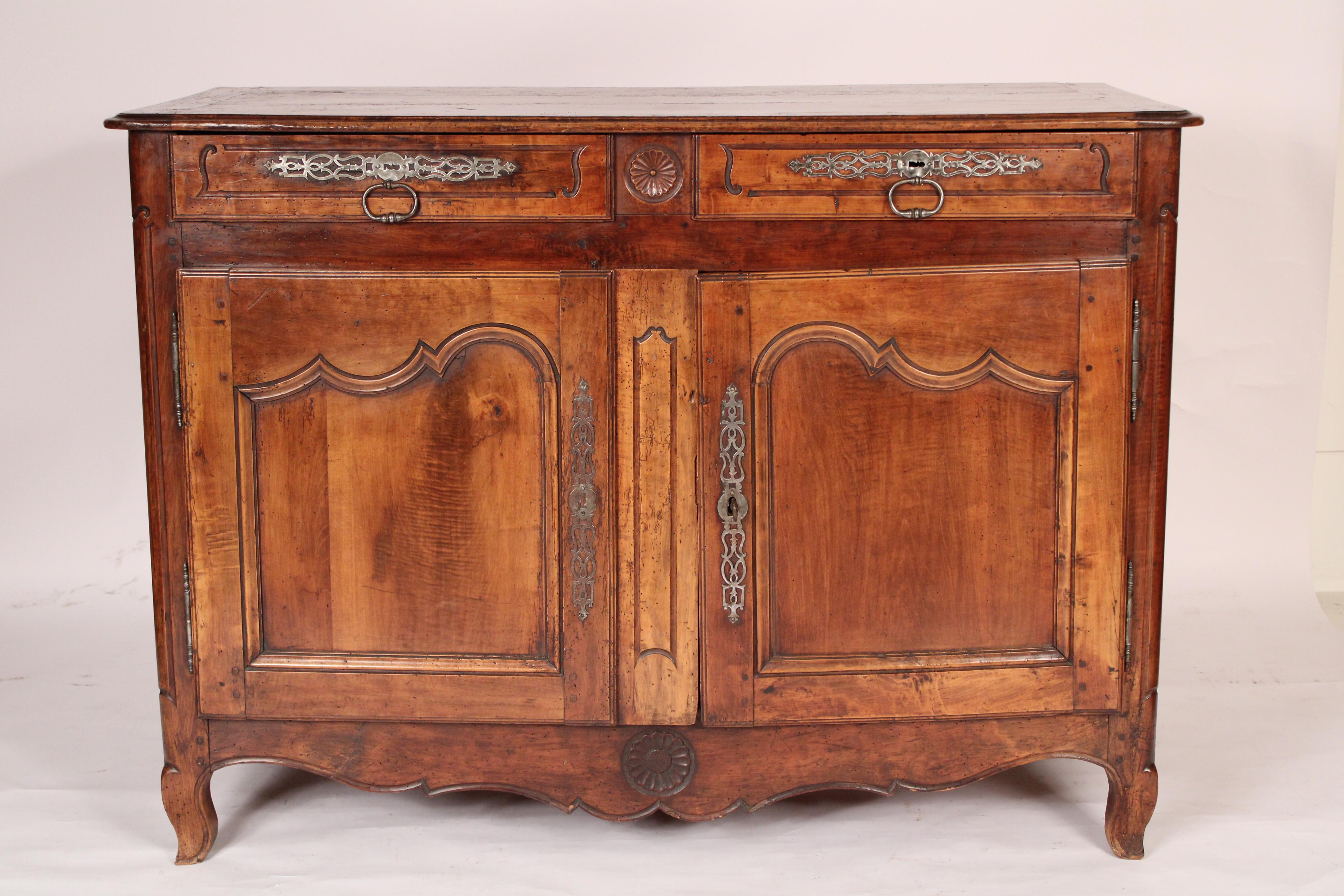 Louis XV provincial fruit wood buffet, 18th century. With a rectangular overhanging top with thumb molded front and side edges and rounded front corners over two drawers with steel hardware over two doors with inset panels, a shaped apron with