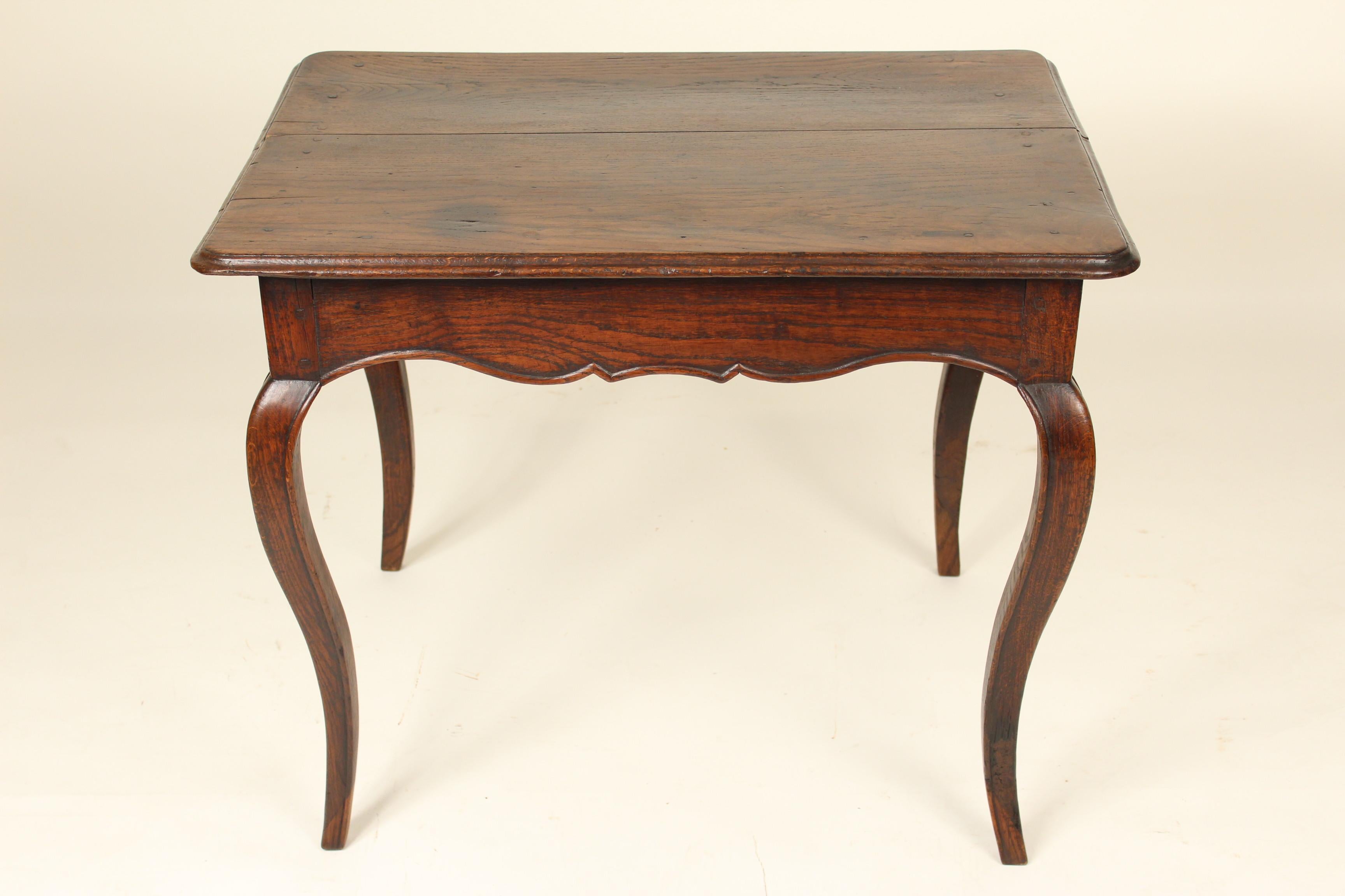Louis XV Provincial oak occasional table, early 19th century. With a two board top, cabriole legs and scalloped apron. Mortise tenon and dowel construction.