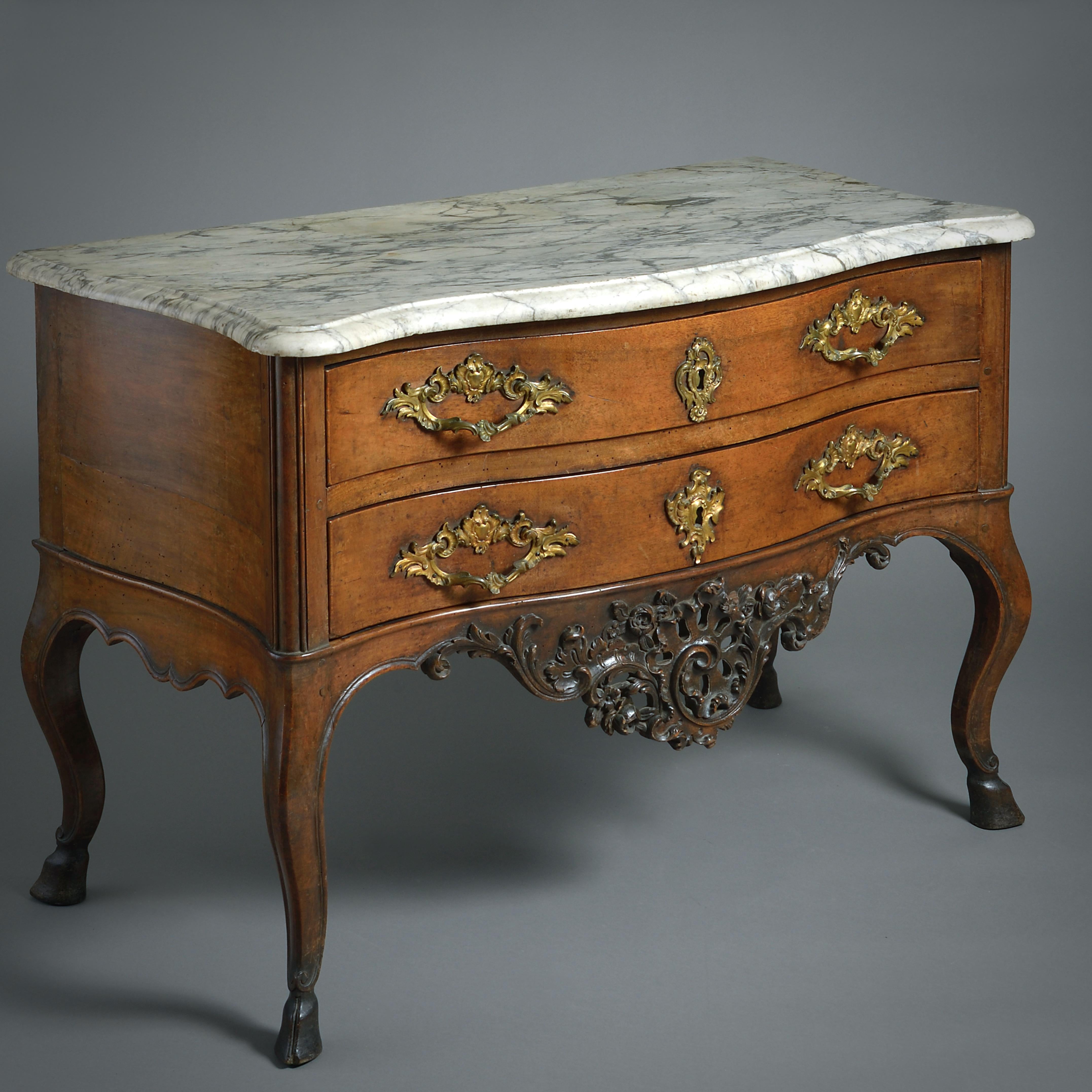 A fine Louis XV provincial ormolu-mounted walnut commode, Rhone valley, circa 1750.

With its original veined Carrara marble top above two drawers and an elaborately carved and pierced apron on cabriole legs with cloven-hoof feet.
