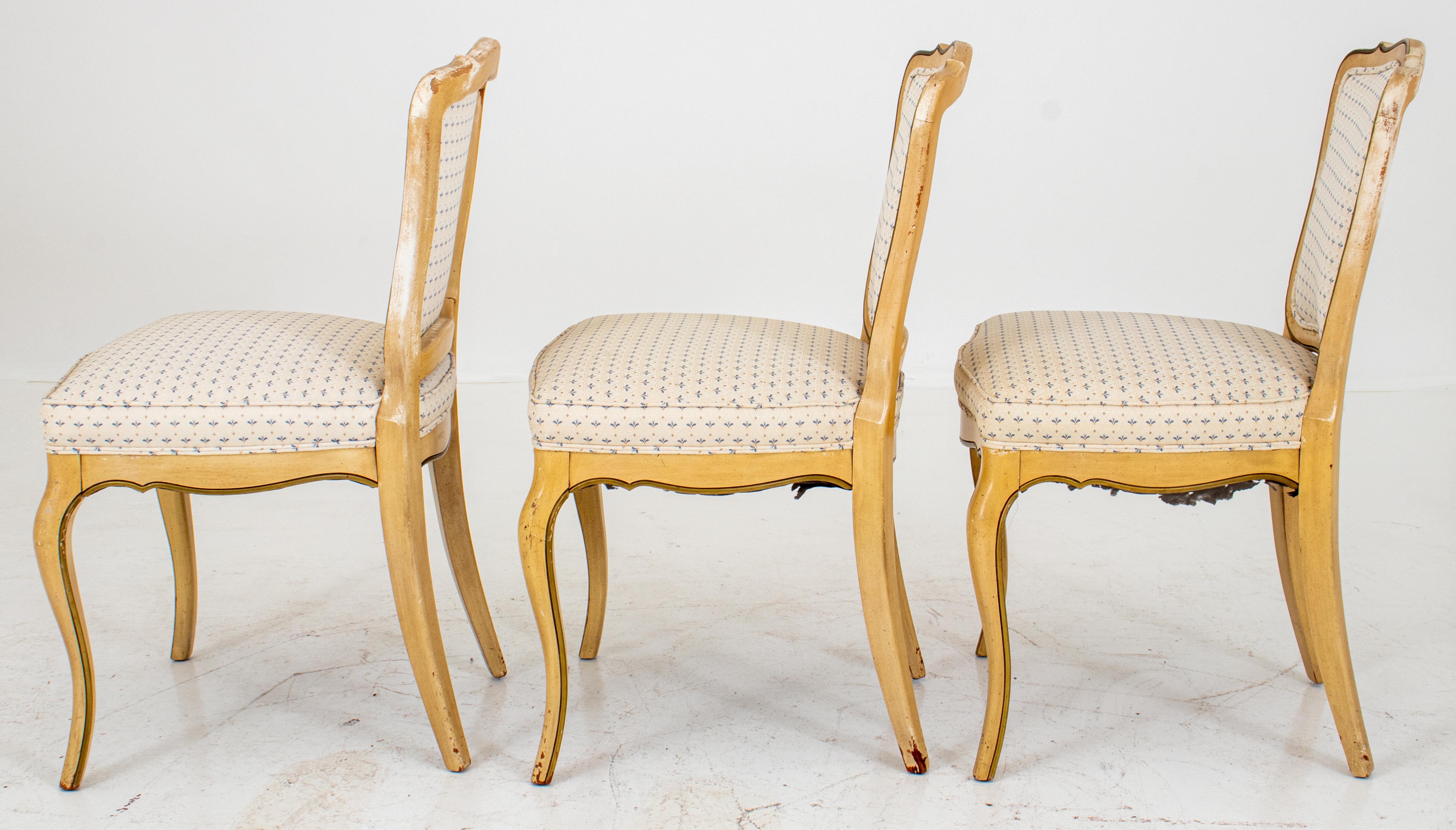 Bemalte Beistellstühle im Louis-XV-Provinzial-Stil, mit geformtem Kamm über einer gepolsterten Rückenlehne und Sitzfläche. Die Stühle sind mit gelber und blauer Farbe bemalt und mit blauem und weißem Jacquard bezogen. Maße: 35