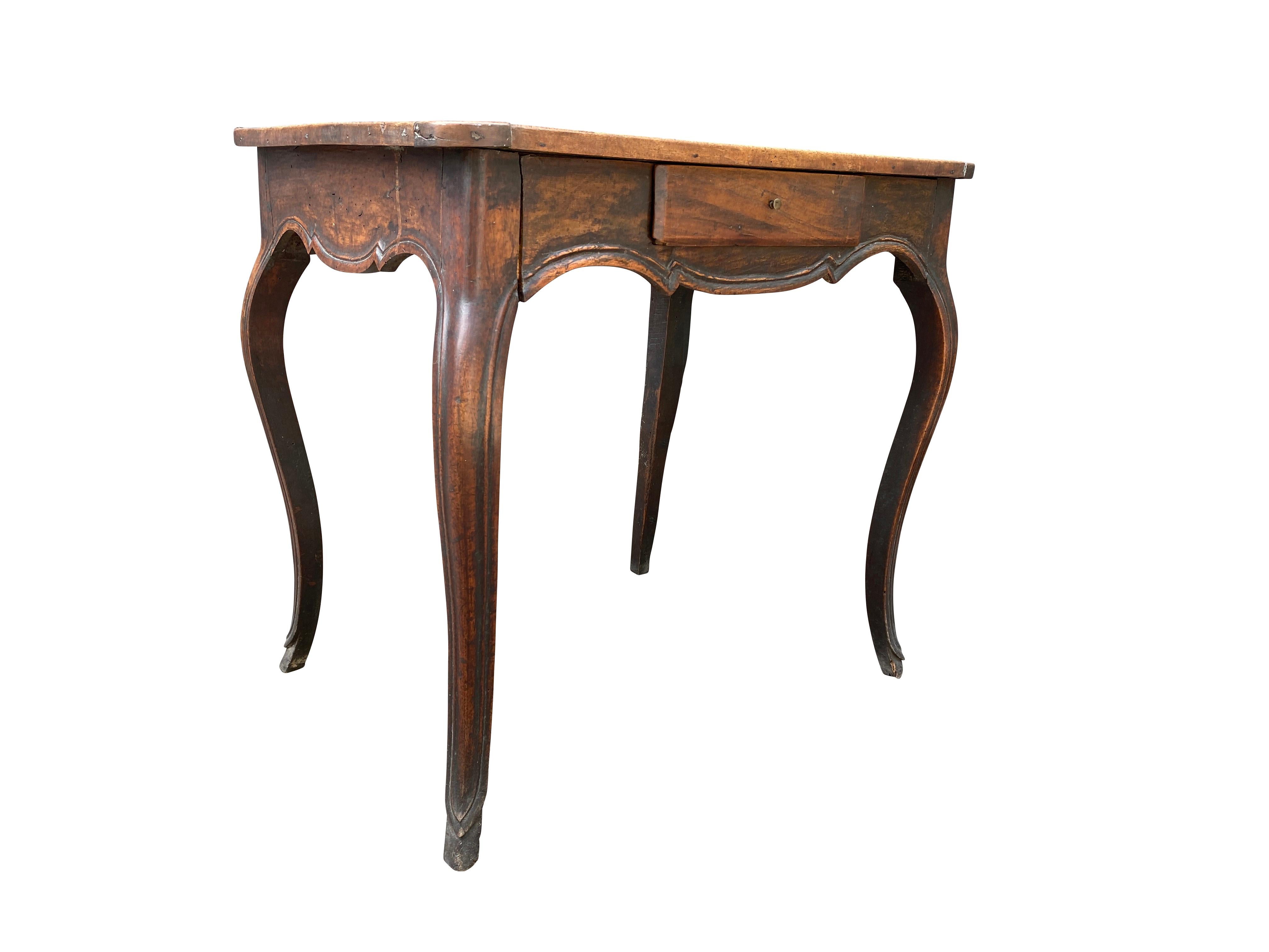 Rectangular top with rounded corners and a conforming frieze with drawer, raised on cabriole legs.
