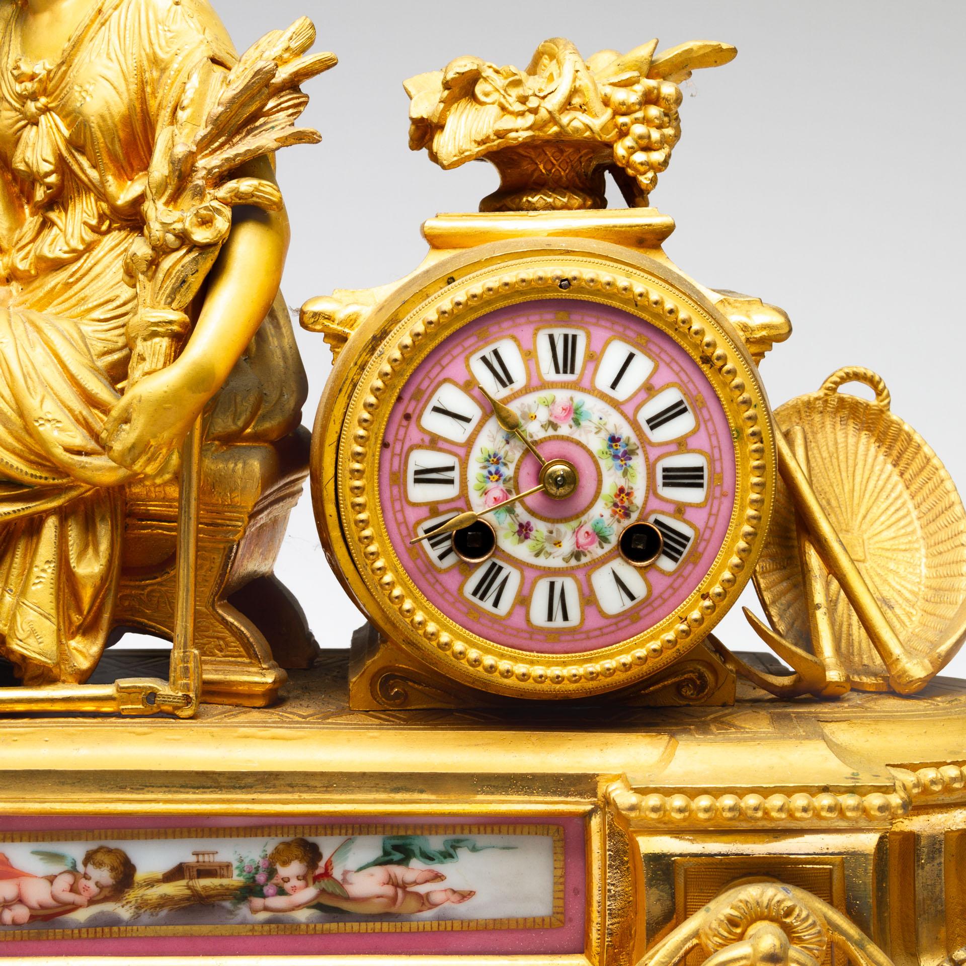 An elegant French gilt metal mantel clock, late 19th century in the Louis XVI style, inset with pink ground Sevres style porcelain plaque and dial painted with putti and flowers, inset with the seated figure of Ceres, the drum cased bell striking