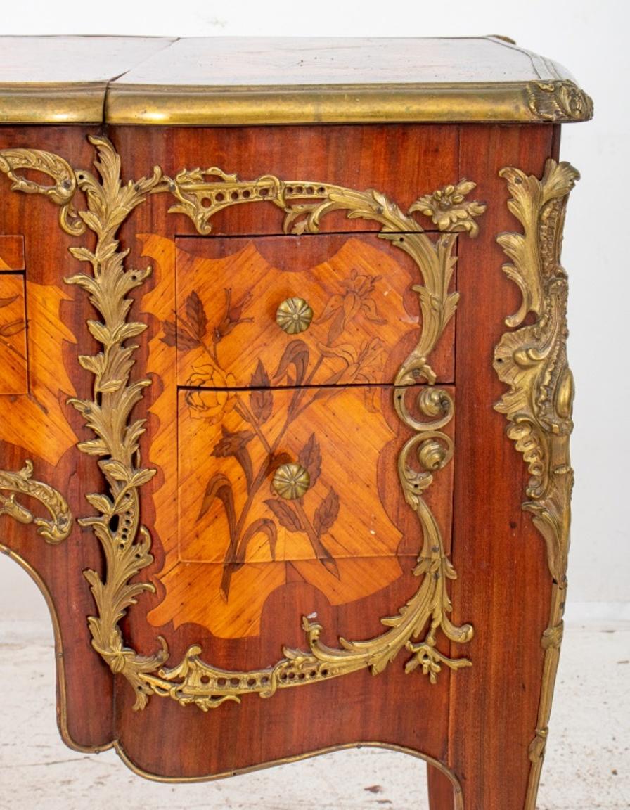 Louis XV Revival parquetry lady's vanity circa late 19th century, with shaped rectangular top in three sections, one lifting to reveal a mirror, two chambers and two short drawers. This vanity features kingwood and other hardwoods with floral