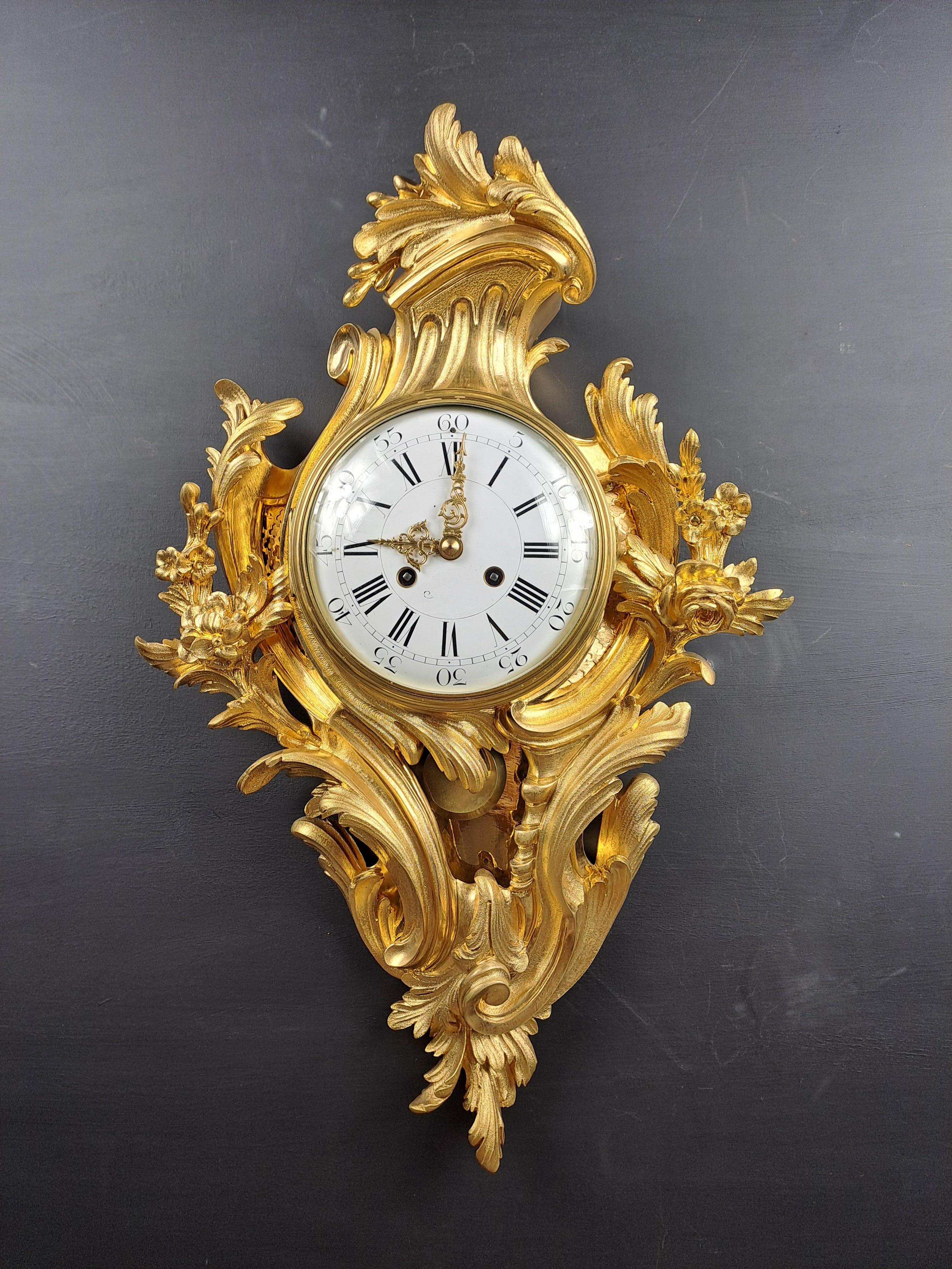 Magnifico orologio da parete in bronzo dorato, finemente cesellato in stile rocaille Luigi XV con foglie e fiori d'acanto.  

 Opera parigina di qualità superba, cesellatura molto bella, doratura eccezionalmente fresca e brillante.    

Ottime