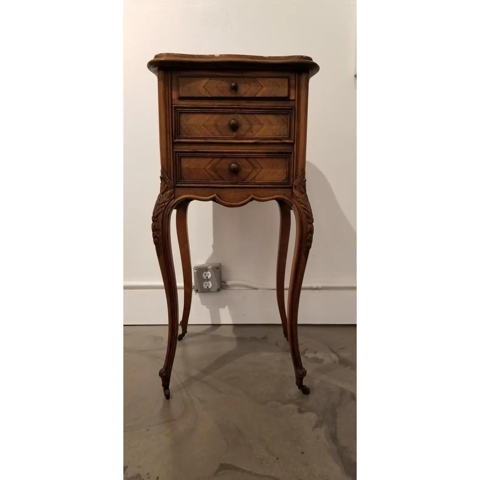 Early 20th century French rosewood and marble bedside or end table. Cabriole legs crafted in solid rosewood with book-matched rosewood sides, drawer faces and back. Sculpted top with original curved marble inset top with bevel. Marble interior