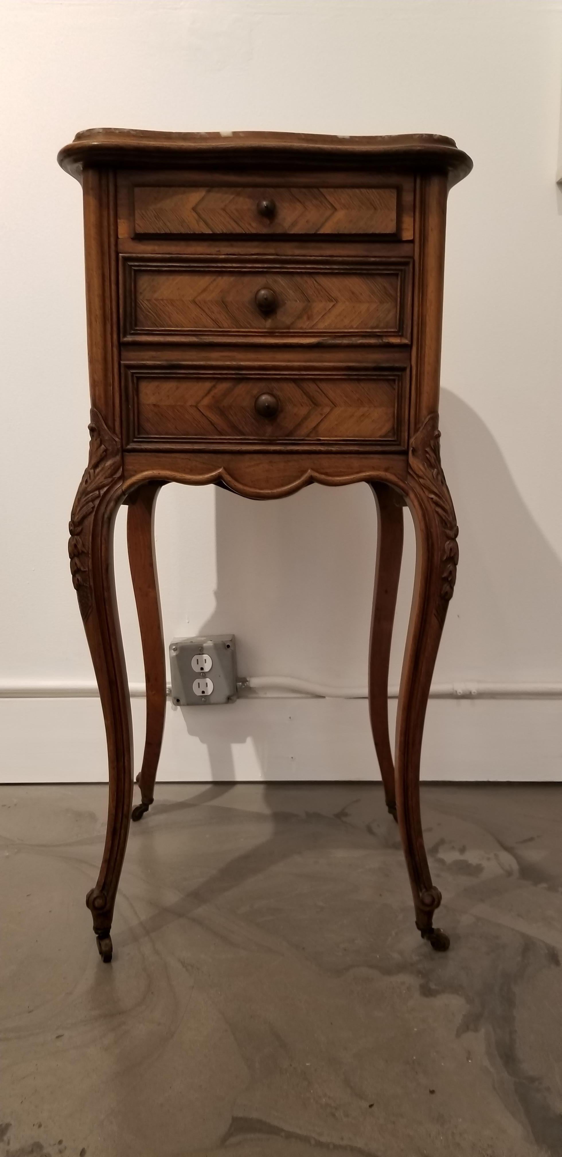 Exceptional early 20th century French rosewood and marble bedside or end table. Cabriole legs crafted in solid rosewood with book-matched rosewood sides, drawer faces and back. Sculpted top with original curved marble inset top with bevel. Marble