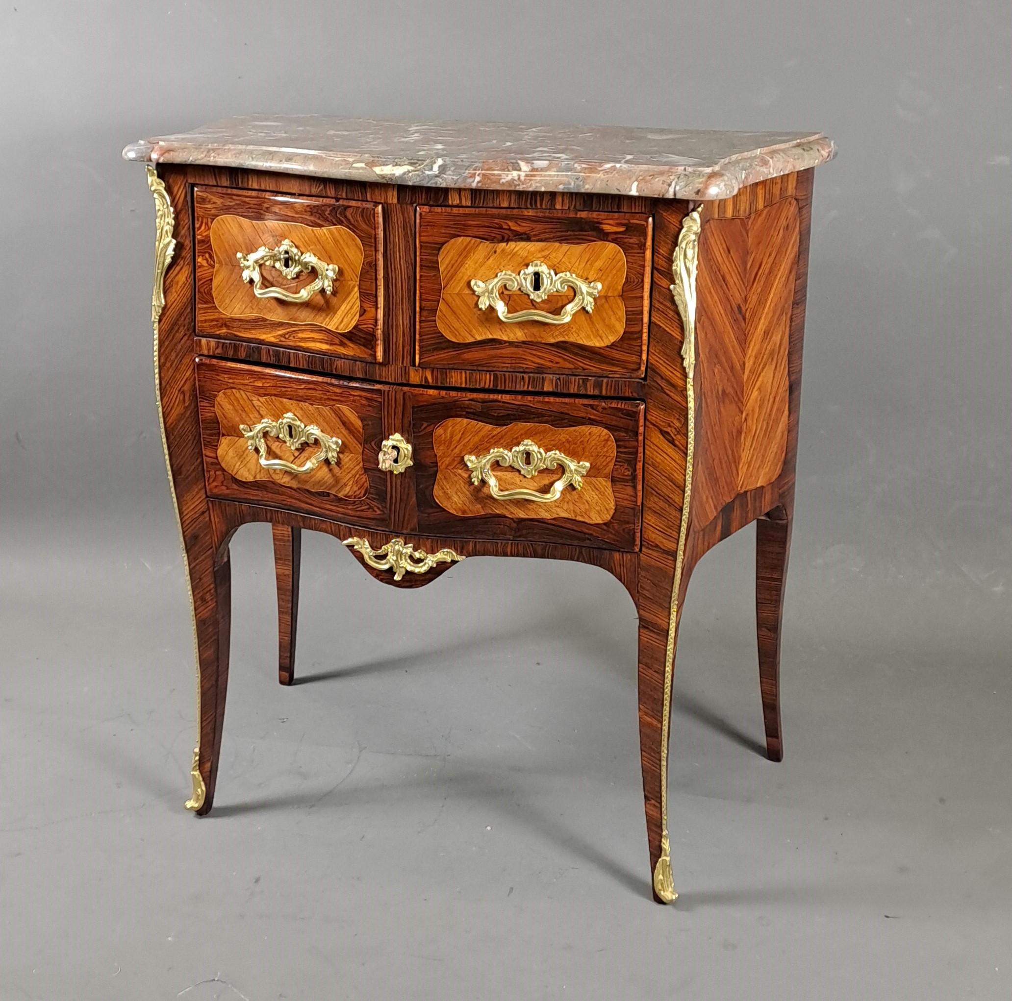 Lovely little Louis XV commode scurved on all sides in rosewood marquetry in curling in scrolled reserves, highlighted with light wood fillets on a rosewood background.
Opening three drawers in two rows.

Flanders marble top molded in Bec de