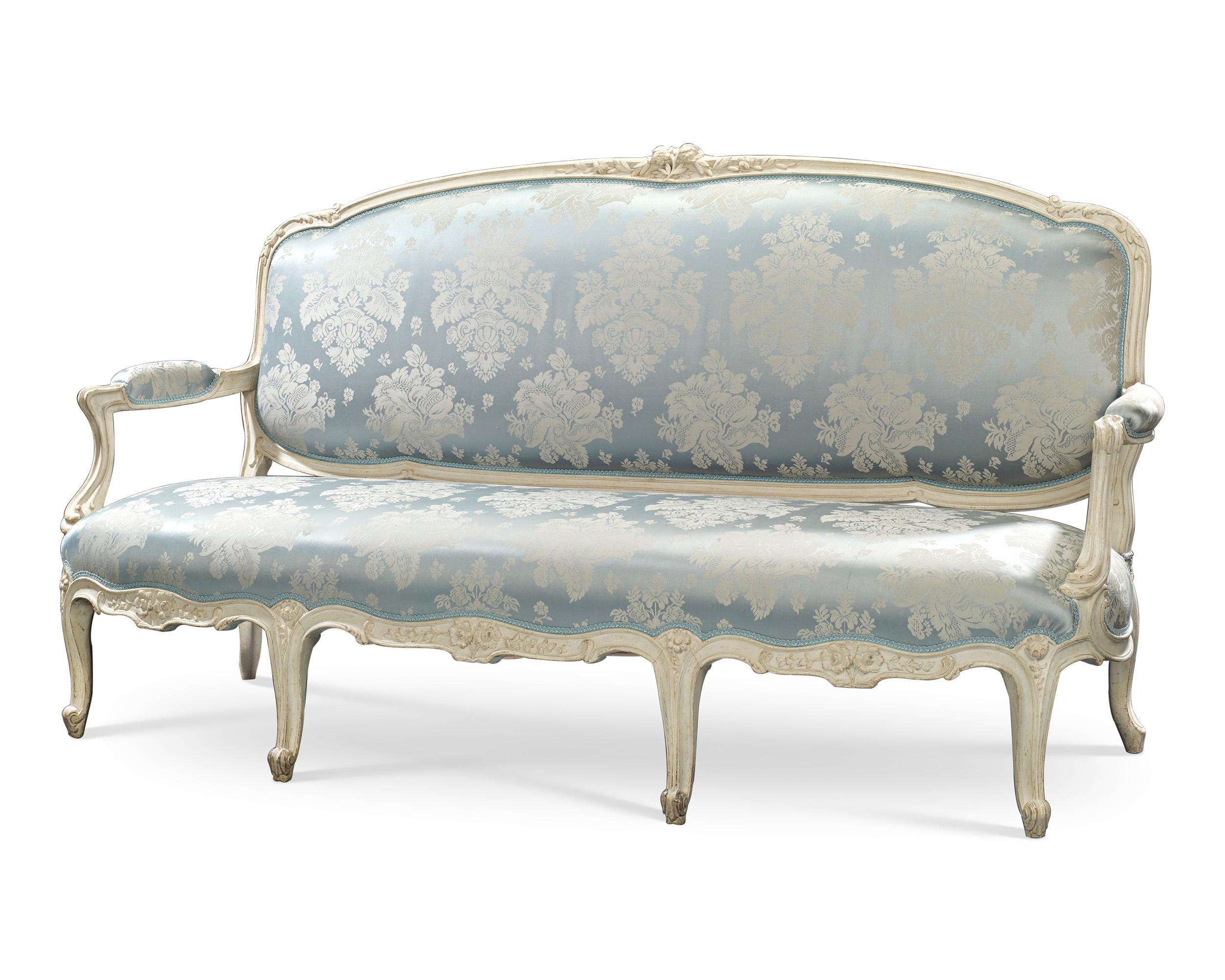 Die Pracht der Epoche Ludwigs XV. ist in diesem unglaublichen Sofa des berühmten Künstlers Jean-René Nadal l'Ainé (1733-1783) eingefangen. Das seltene Sofa, das mit einem blau-weißen Stoff bezogen ist, der das Weiß des Holzes ergänzt, spiegelt den