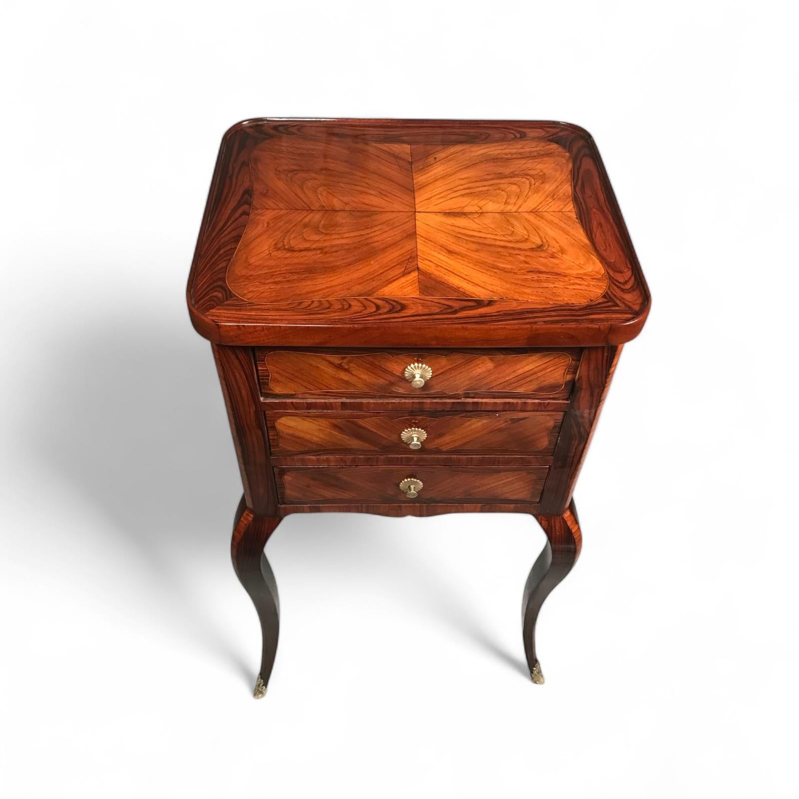 Exquisite 1760 French Small Side Table with Kingwood Veneer

Discover this stunning 18th-century French small side table, also known as a commode, crafted in 1760. Featuring a luxurious Kingwood veneer with a striking pattern, this antique boasts
