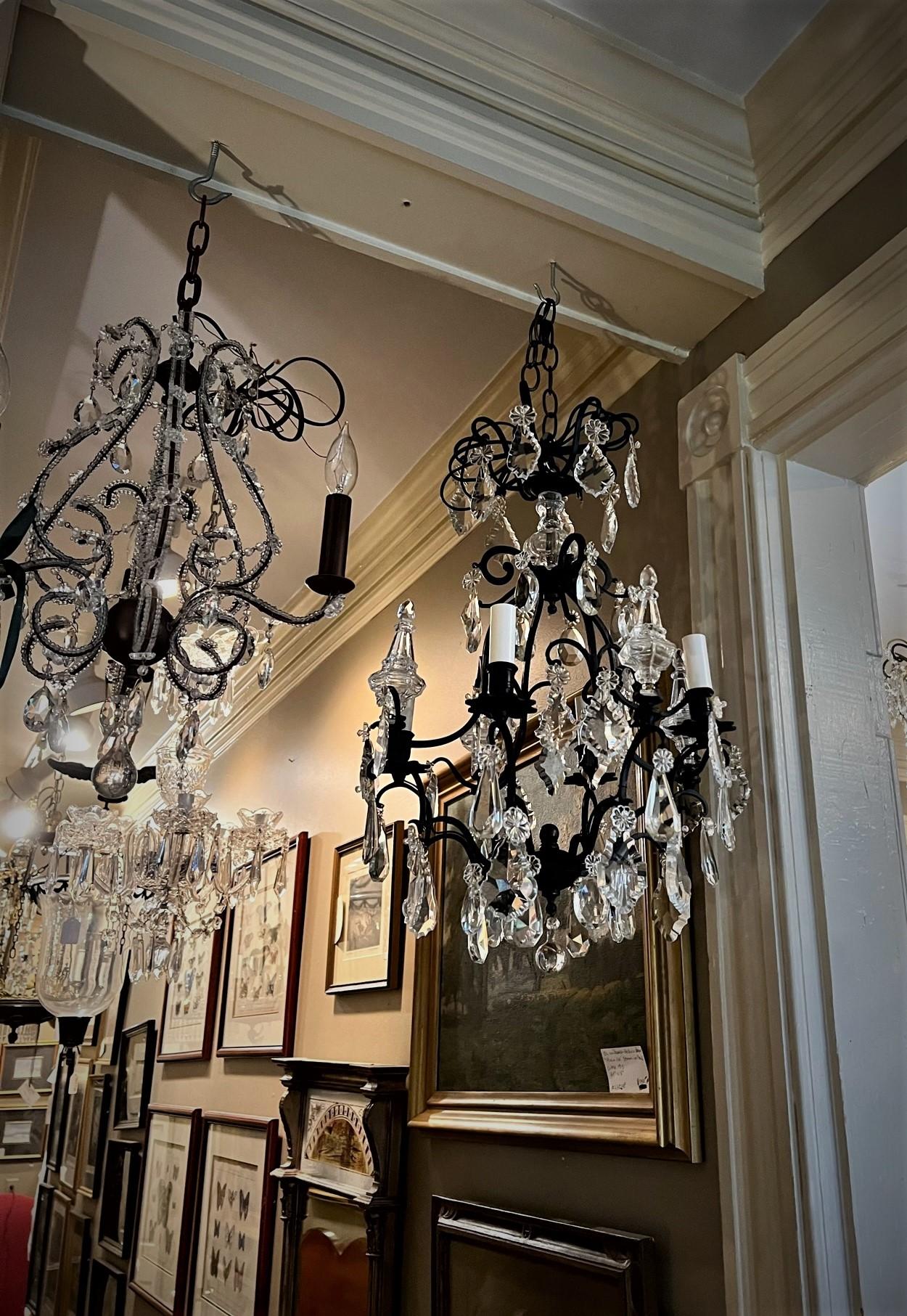 This beautiful Louis 15th style fixture has a hand-wrought cast iron frame and hand-cut Baccarat style prisms and spikes. It is perfect for the foyer, breakfast room, stairwell or any place a charming chandelier is needed. Ceiling cap, hanging