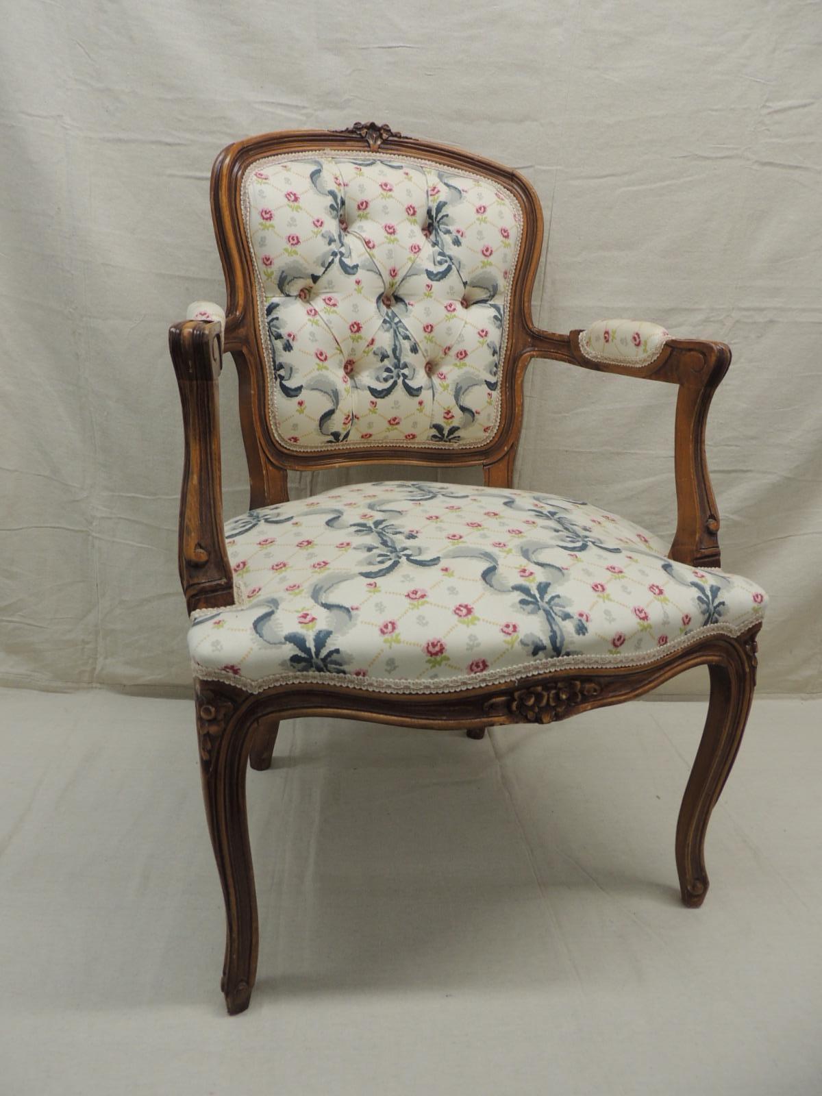 Louis XV style antique petite armchair.
Floral and ribbon cotton fabric upholstery.
In shades of green, blue, pink on an off-white background. Honey color wood frame with padded arms.
Tufted back trim with pink, green and natural gimp all