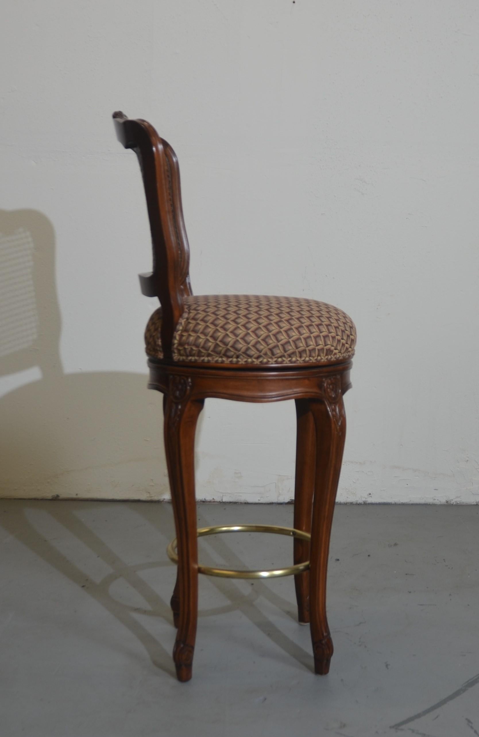 Louis XV style set of four cane barstools. The seats swivel with pattern upholstery.