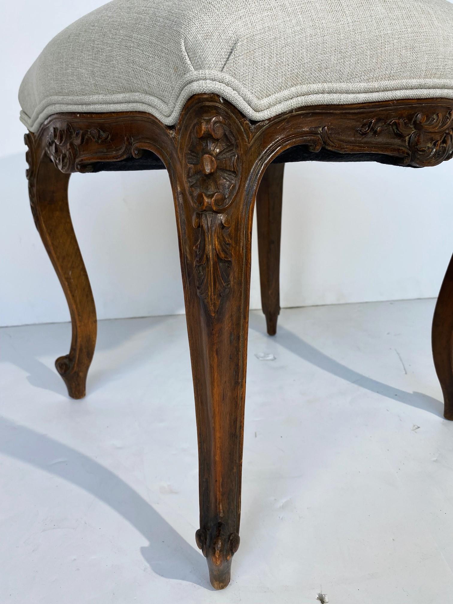 A Louis-style French finely carved bench. New upholstery.