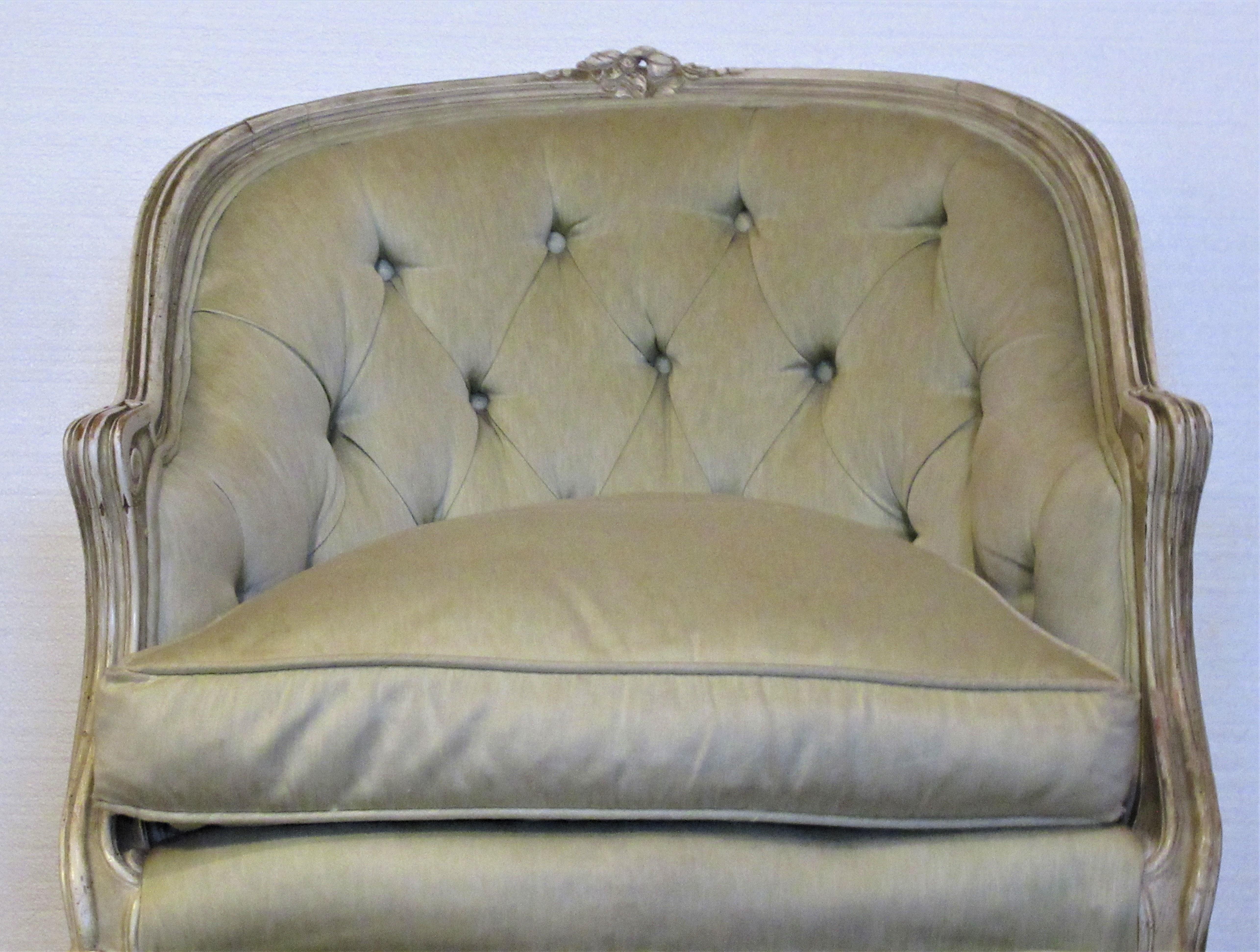 Louis XV style bergère in old cream white surface and original pale celery green upholstery with down filled seat cushion, circa 1950-1960.