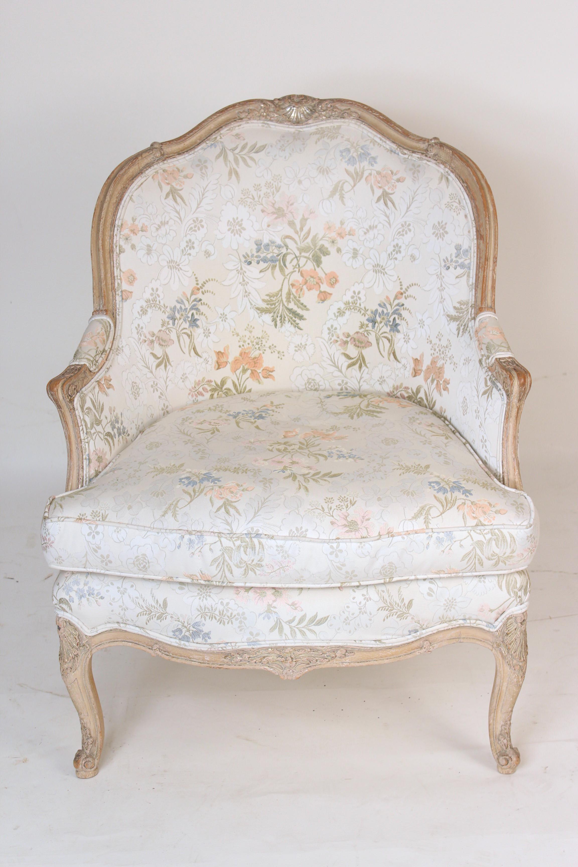Louis XV style bergere with painted finish and traces of silver leaf, mid-20th century. This chair has very nice quality upholstery.