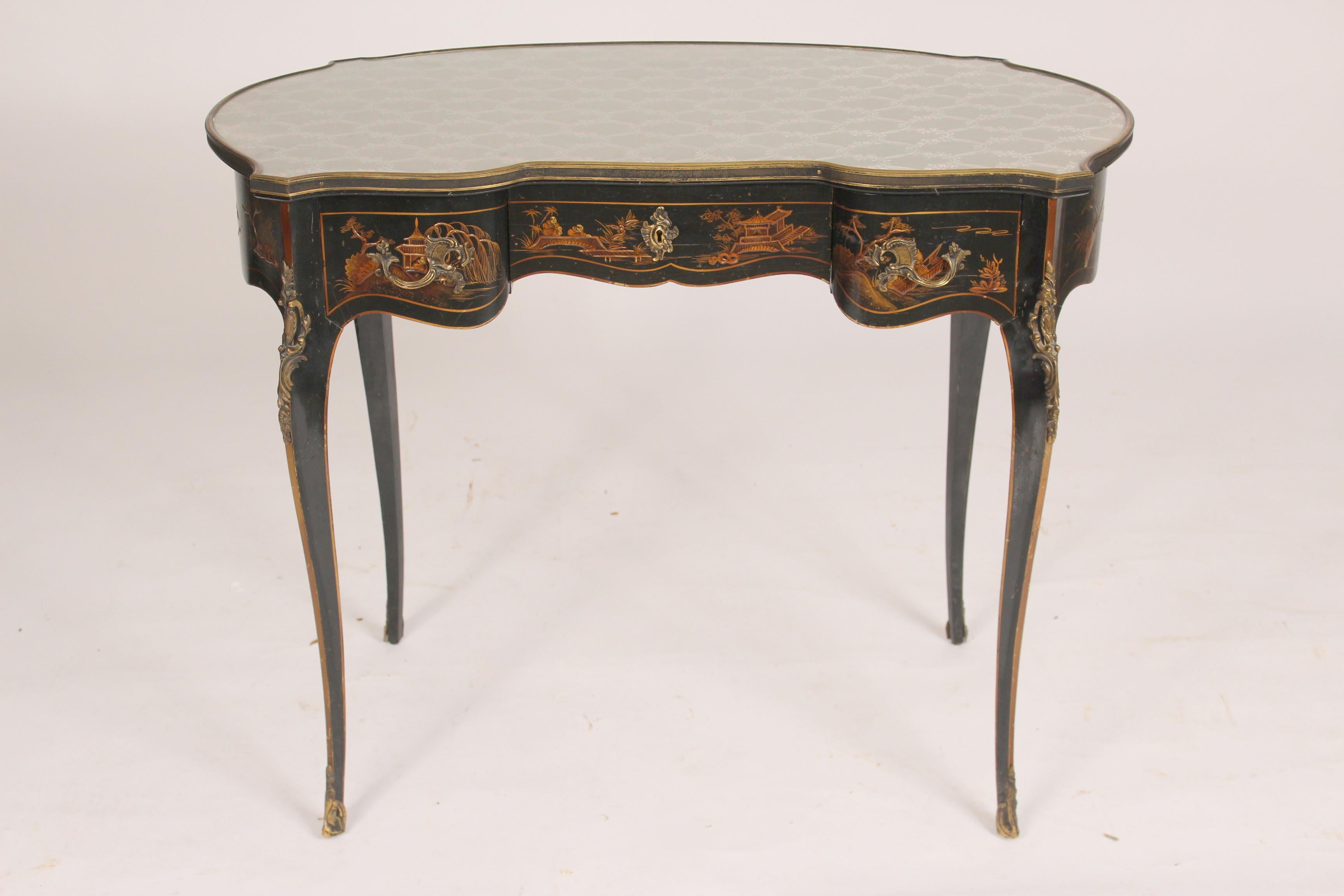 Louis XV style black chinoiserie decorated vanity / desk, circa 1970's. With a fabric and glass top, raised chinoiserie decoration and brass hardware.