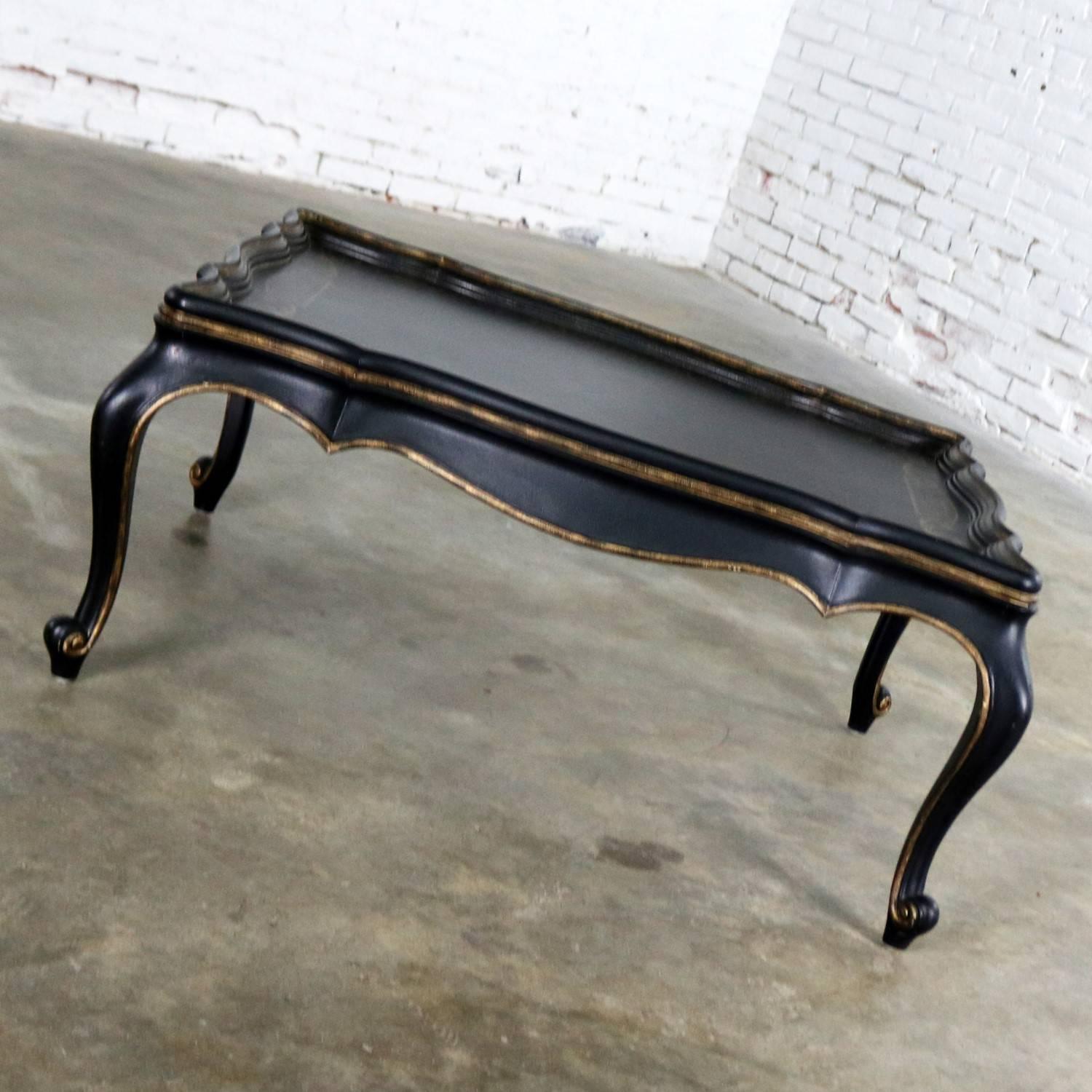 Handsome black coffee table with gilt chinoiserie details in the style of Louis XV. This table is in wonderful recently vintage condition. It does show some wear that adds to its lovely intended age patina, circa 1990s.

If you are looking for a