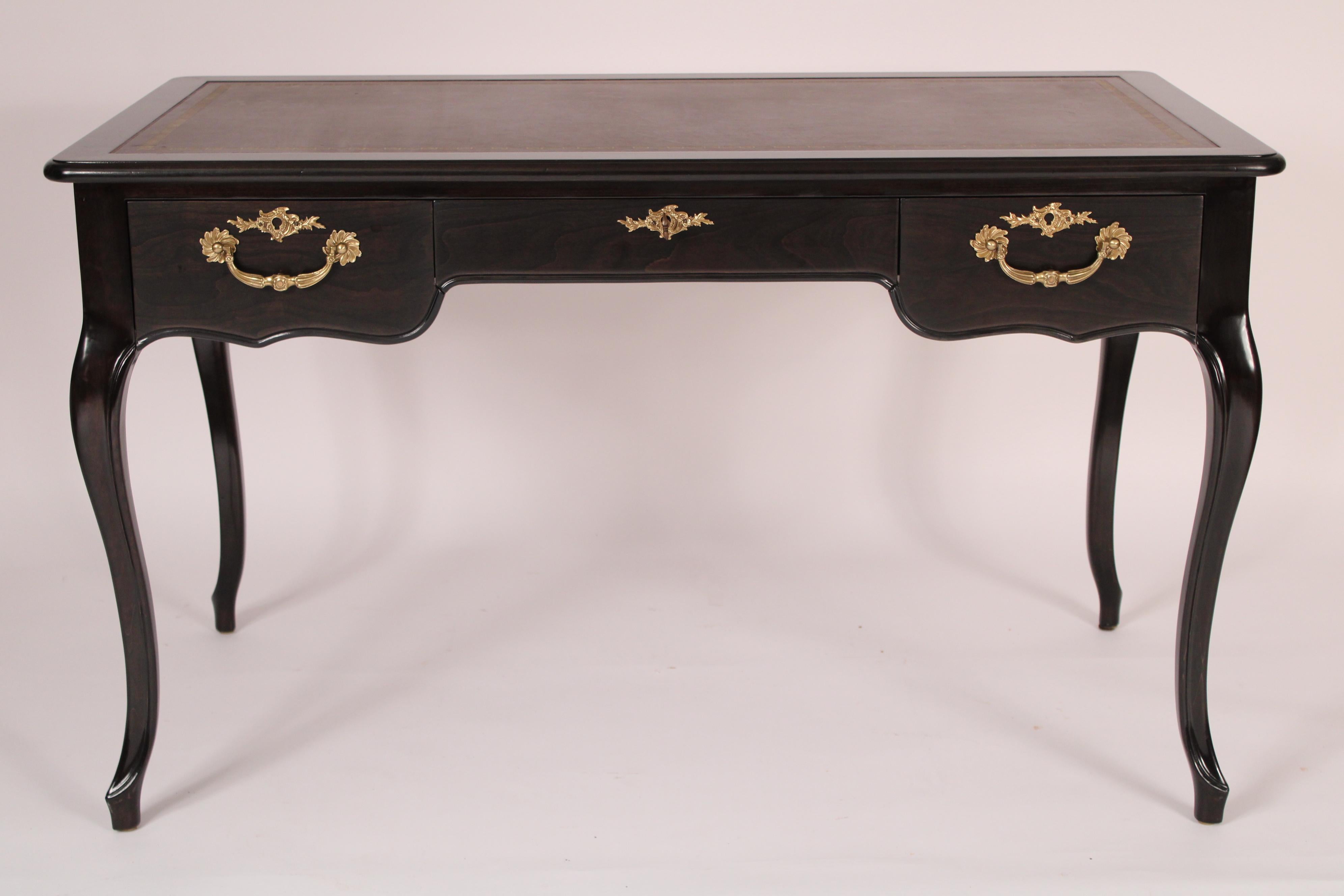 Louis XV style Black lacquer writing table, circa 2000. Made by Baker. With a rectangular overhanging top with rounded corners the top inset with tooled leather, 3 frieze drawers the outside drawers with bronze pulls, resting on cabriole legs.