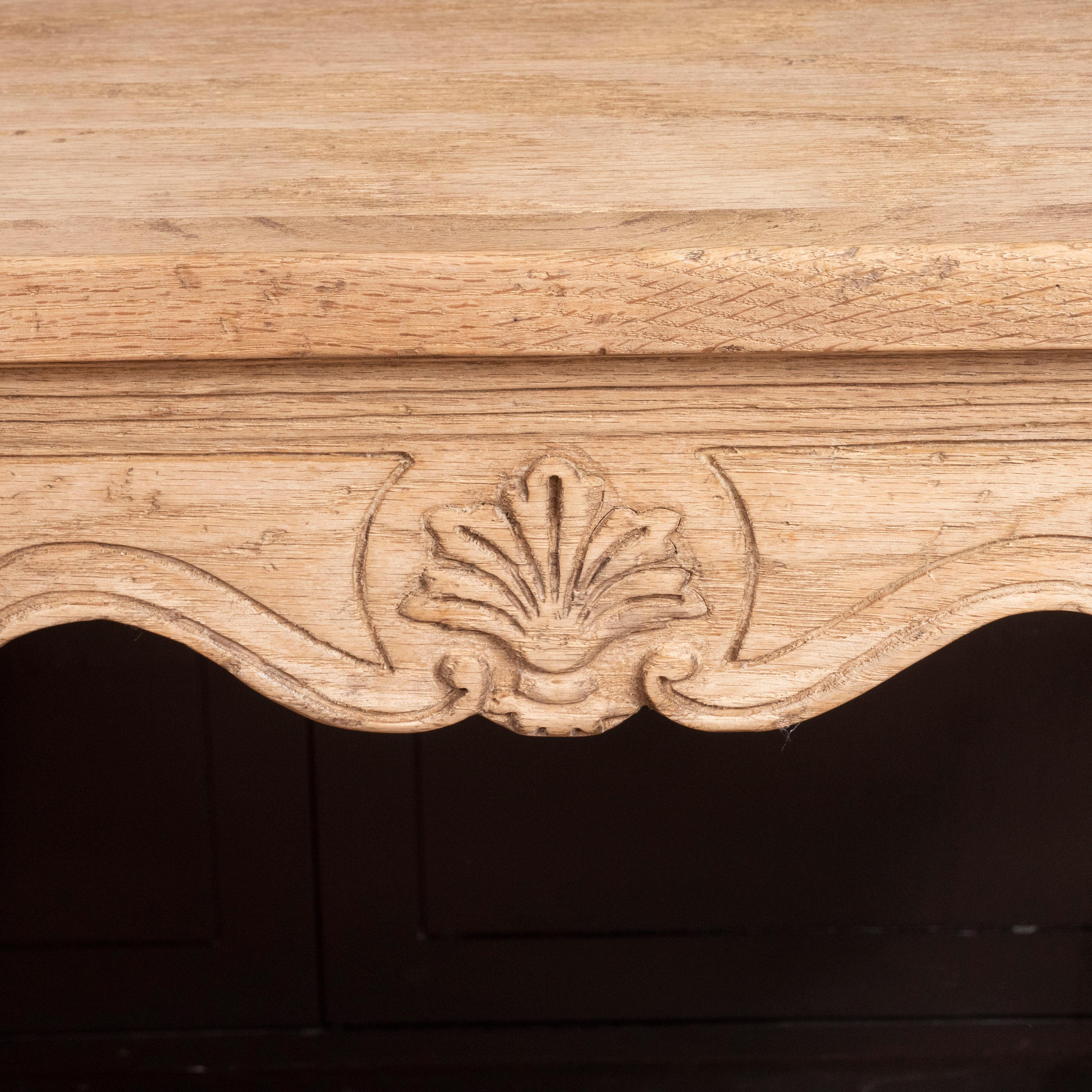 A Louis XV style bleached oak table with beautiful wood carving on the base and legs. Elegant, yet understated, the bleached finish gives a fresh look to a traditional piece.