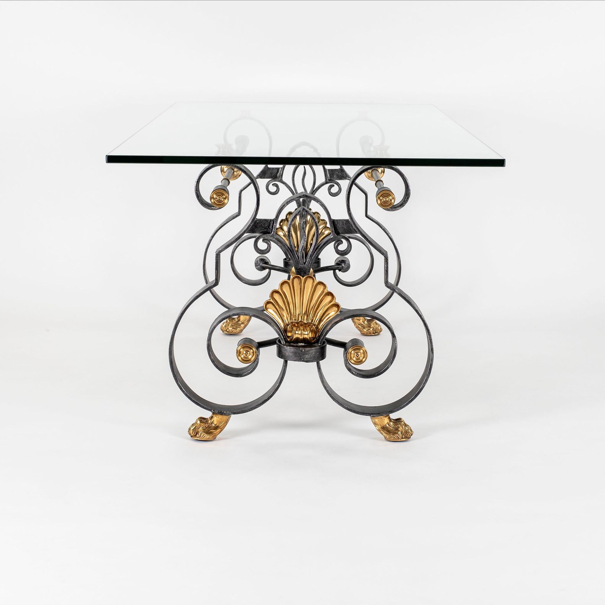 Vintage Louis XV style brass, iron and glass dining table. Heavy base is made of thick scrolled flat iron detailed with polished brass medallions, shell cartouches and lion's feet.