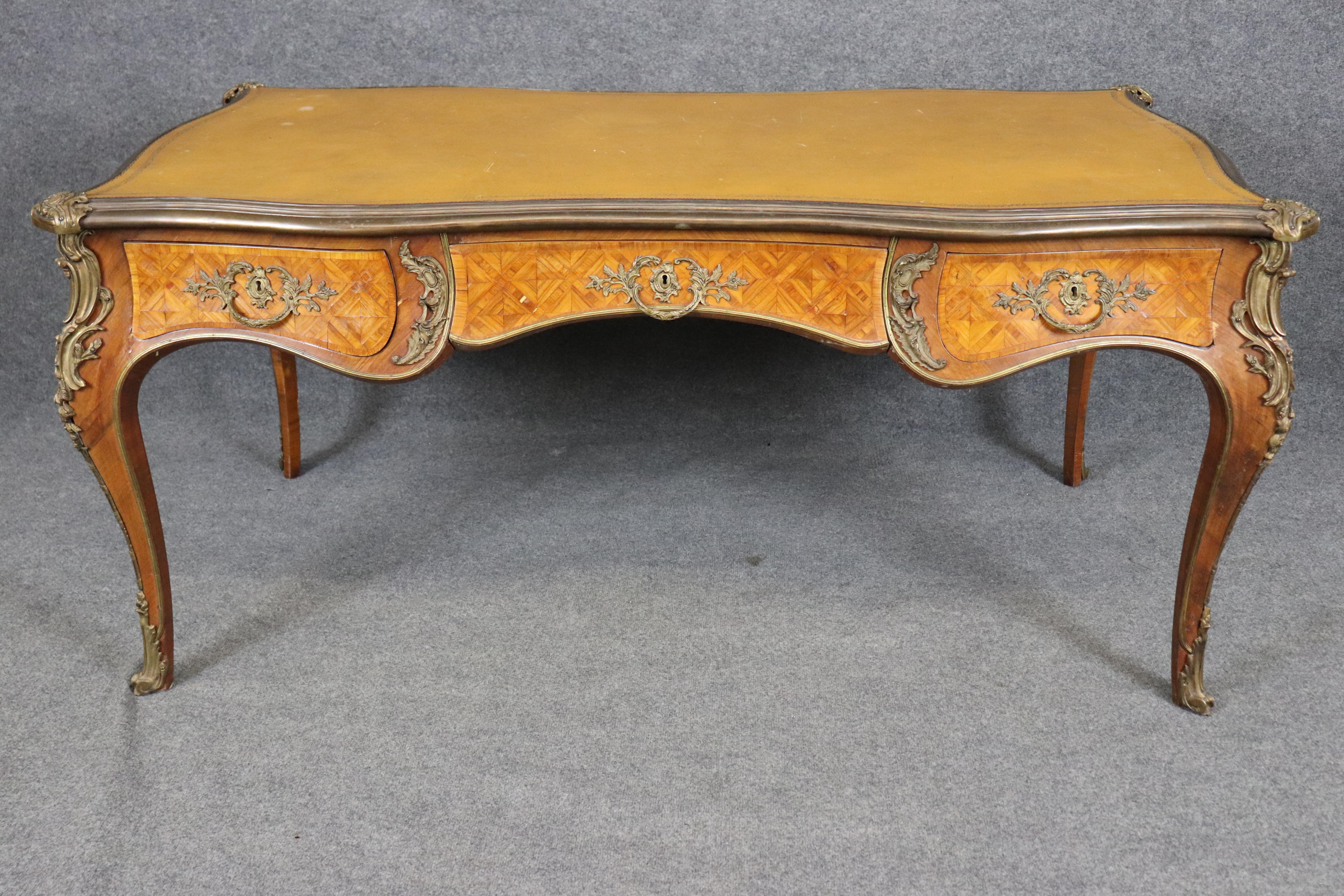 Si tratta di una scrivania straordinaria con una superba fusione di bronzo e noce intarsiato. Il piano in pelle è in buone condizioni con lievi segni dell'età e dell'uso e la cassa presenta lievi segni dell'età e dell'uso come scheggiature