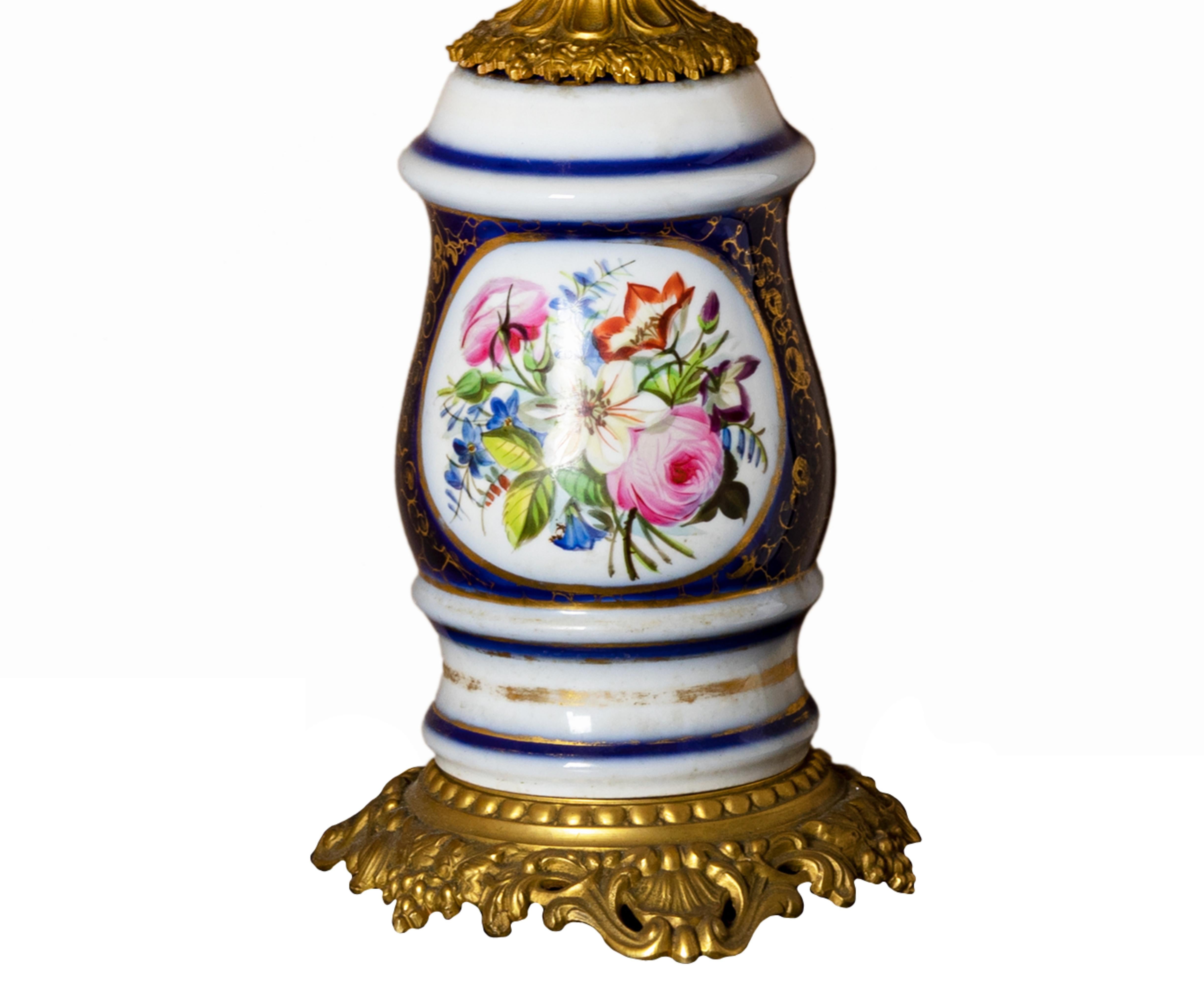 A porcelain table lamp with a Sevres flower bouquet motif and gilded bronze decorated with a golden wreath on feuillagée.
Twisted golden electrical cable. In working conditions.

Height with lampshade: 61 cm
Height without lampshade: 48,5 cm