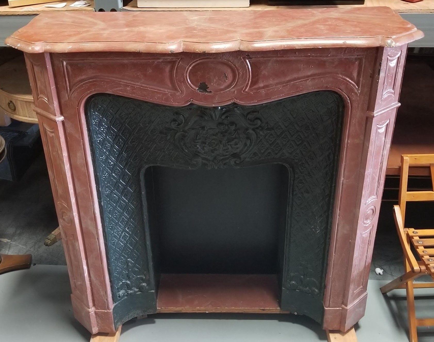 The Louis XV Style Burgundy Metal Faux Fireplace Mantle combines the opulence of the 18th century with modern materials. Crafted from durable metal, it boasts intricate Louis XV motifs, finished in a rich Burgundy hue. This elegant piece adds a