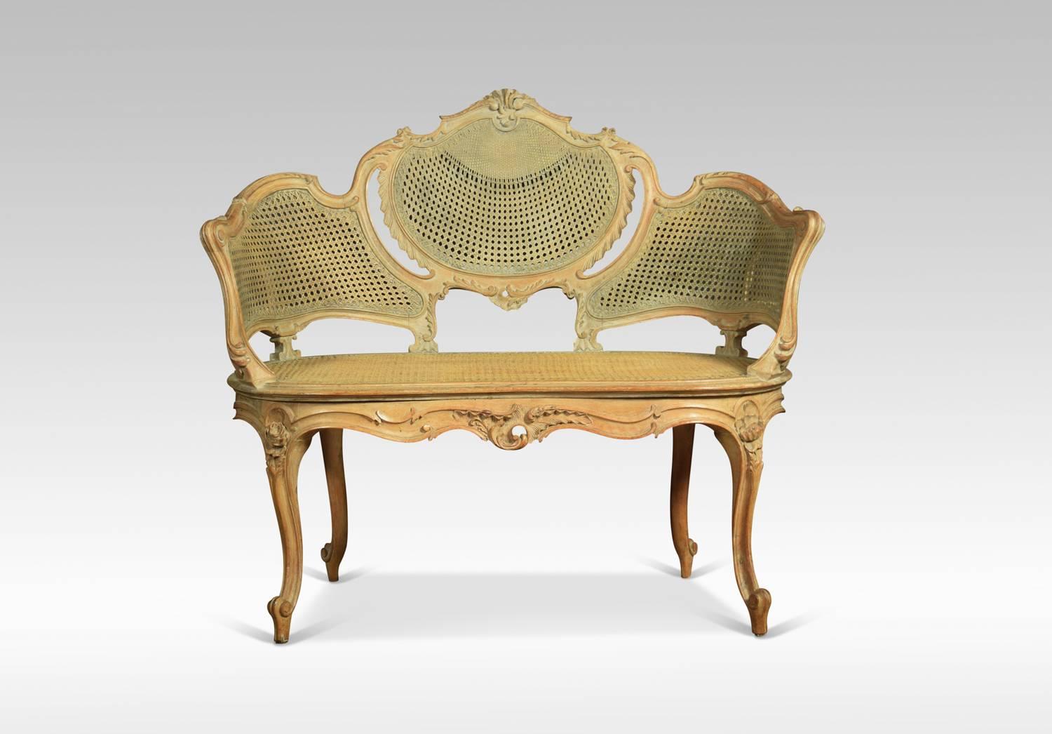 French Louis XVI style canapé settee, the carved rail in the typical manner of the period, with detailed leaf motifs. To the scrolling arms, flanking around canework back and seat. The canape´ rests on four carved tapering cabriole
