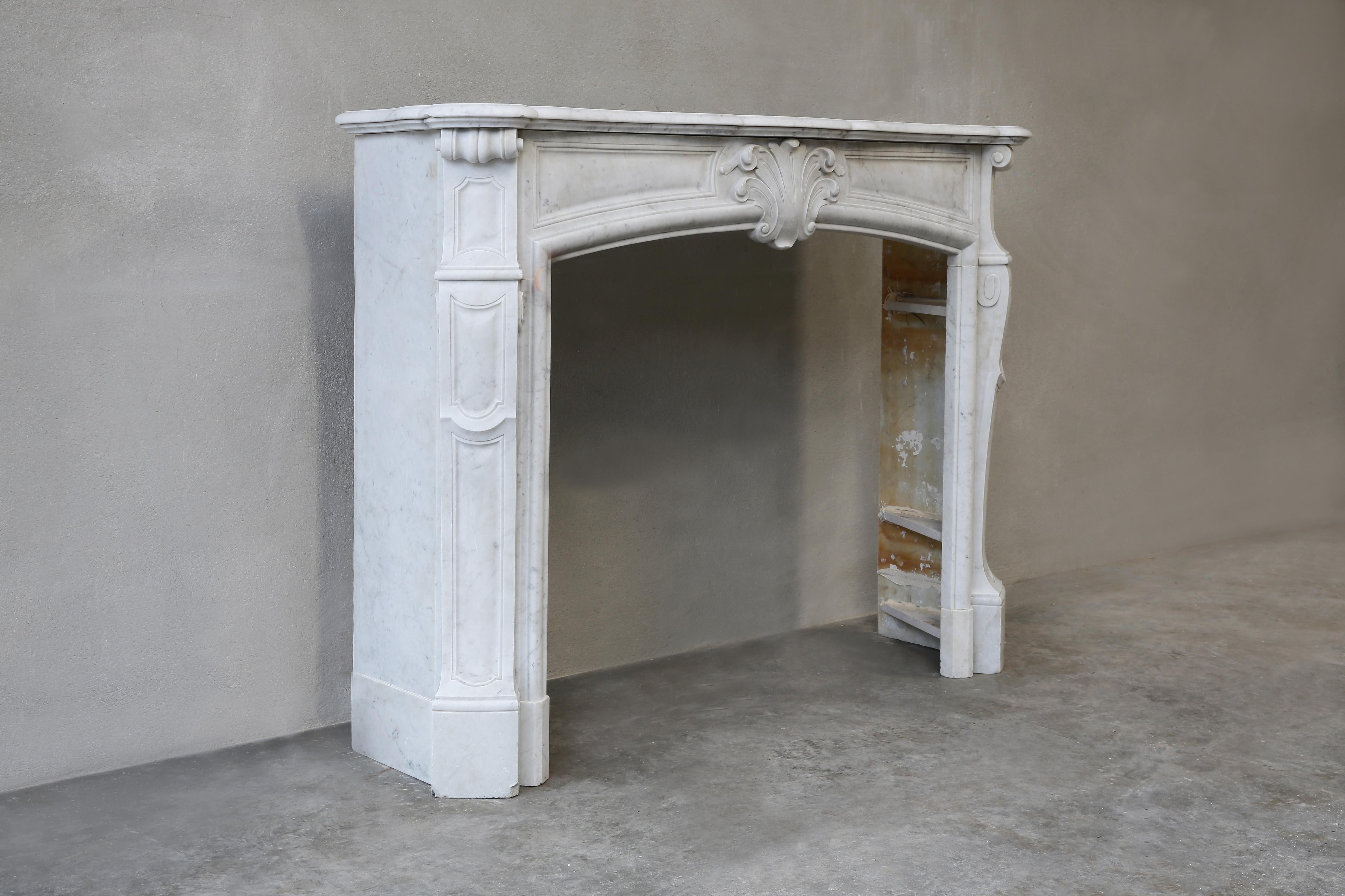 A 19th century fireplace in Louis XV style with a scallop in the middle! This elegant mantel (fireplace) has beautiful round shapes and lines and is chiselled by hand from Carrara marble. Carrara marble is originally from Carrara, a city in Tuscany!