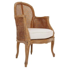 Sillón tallado de estilo Luis XV con trabajo de caña de doble cara en los paneles laterales