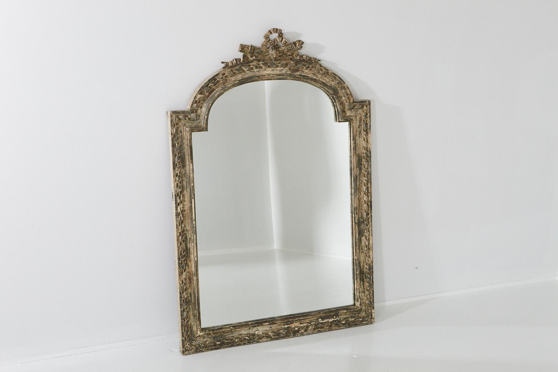 Large Louis XV style carved wall mirror with a distressed finish which is a style element, circa mid-19th century. The frame shows some paint loss, otherwise very solid, the mirror is in very good condition.