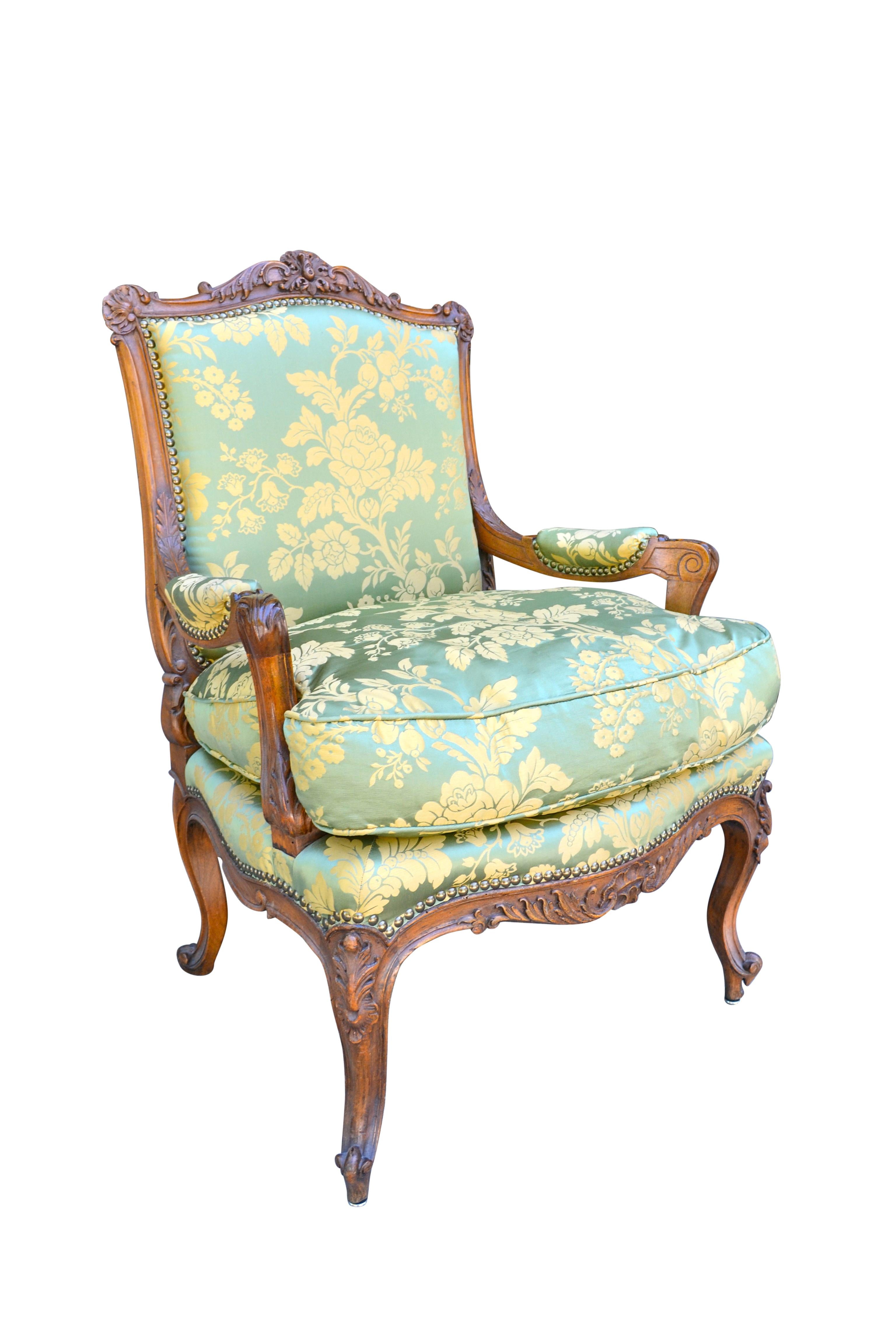 A beautifully carved Louis XV style open armchair the frame in walnut, made in the manner of Charles Crescent one of the more famous 18th century French chair makers. The chair has a loose down filled seat cushion; recently upholstered in new green