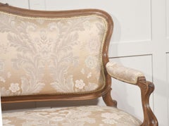 Sillón de nogal tallado estilo Luis XV con tapicería de damasco