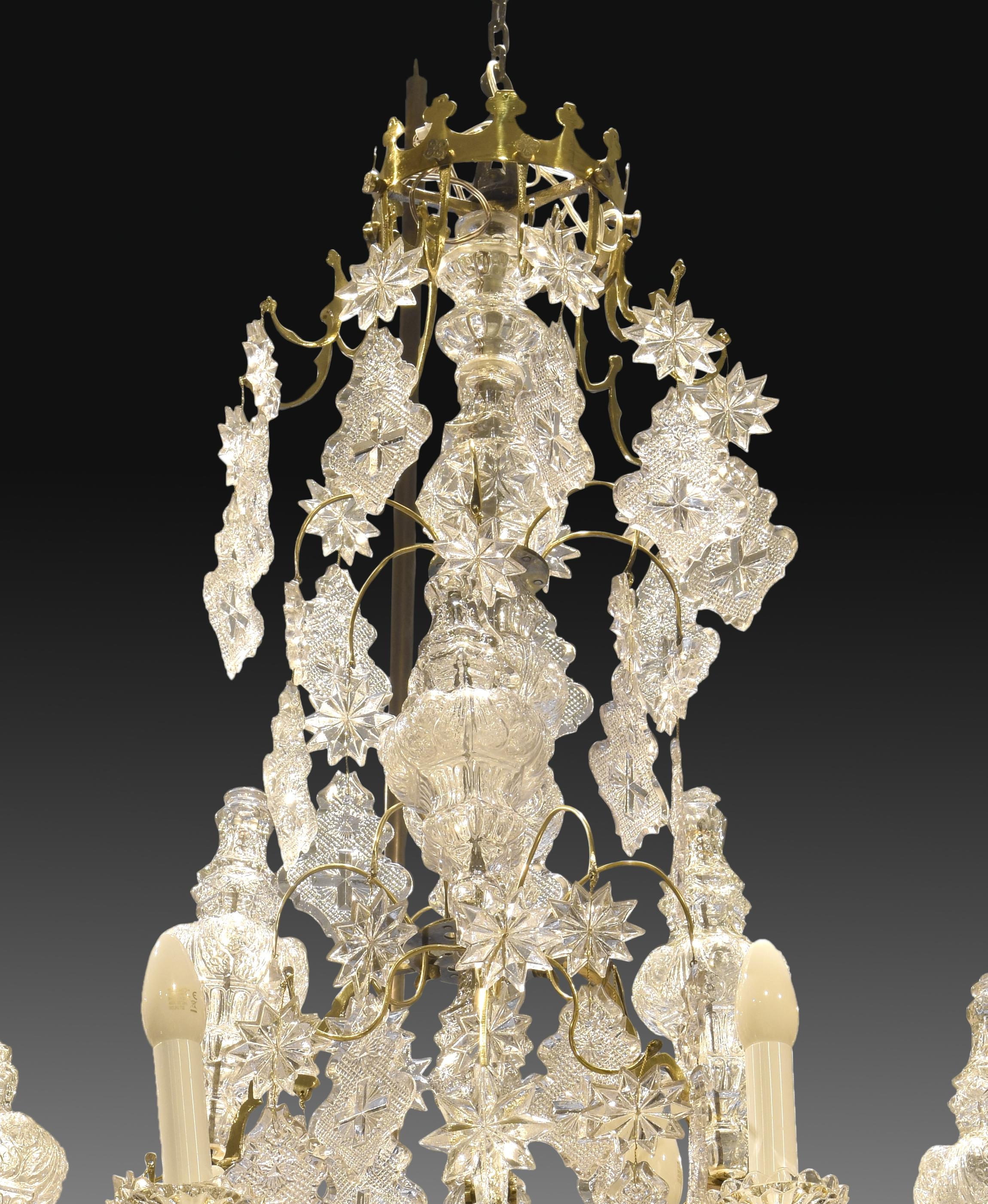 Louis XV style chandelier; twelve lights. Glass, bronze. Baccarat, France, 19th century. Signed. Adapted to electric light. 
 Chandelier for ceiling with a body of gold metal as an axis from which a series of rods of the same material depart in