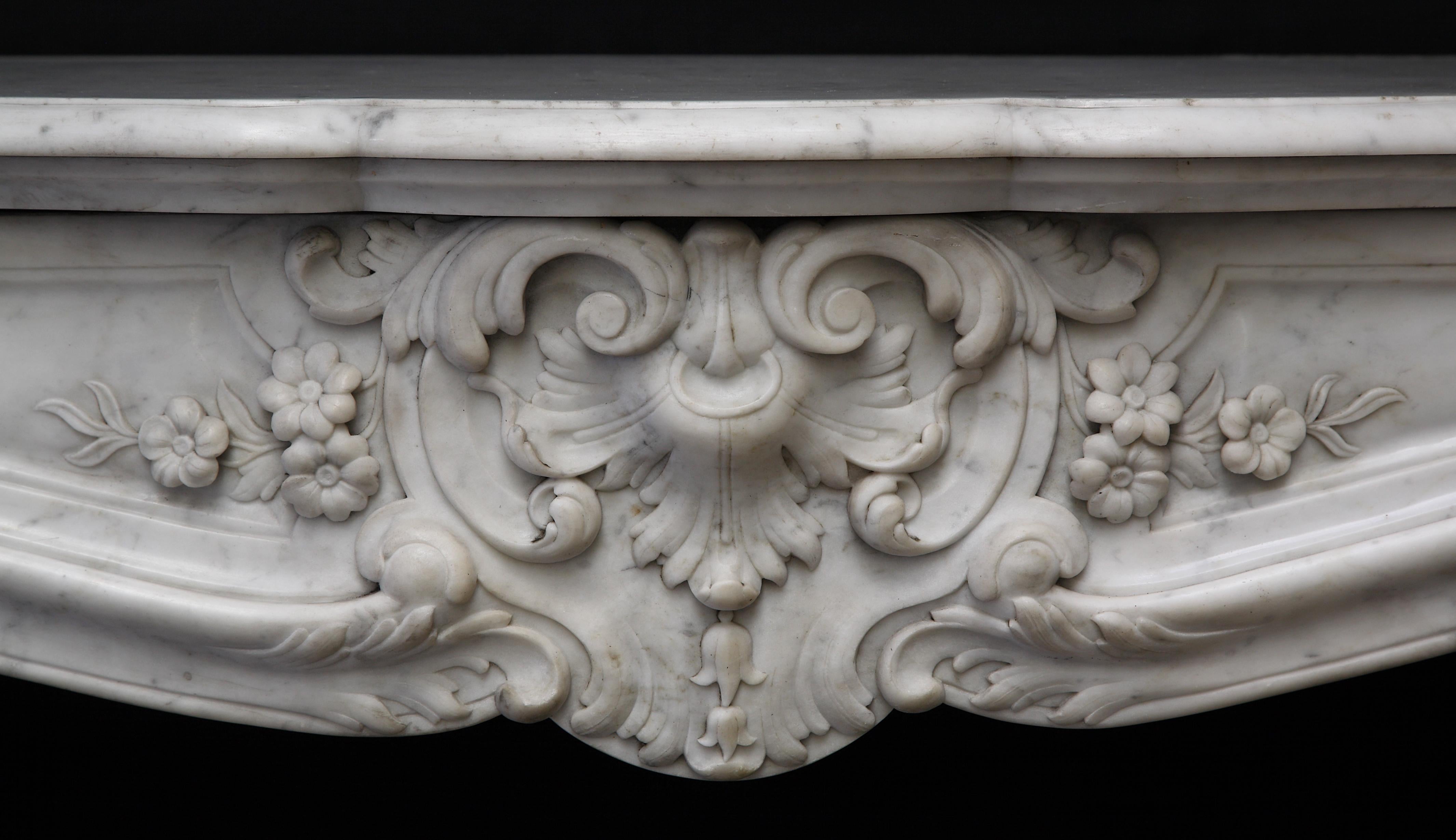 A fine large Louis XV style chimney mantelpiece, made in serpentine shaped white « Carrara » marble, ornamented with scrolls, flowers and a centering shell cartouche.

Measures: Height : 108 cm (42 1/2 in.) ; Width : 144 cm (56 2/3 in.) ; Depth :
