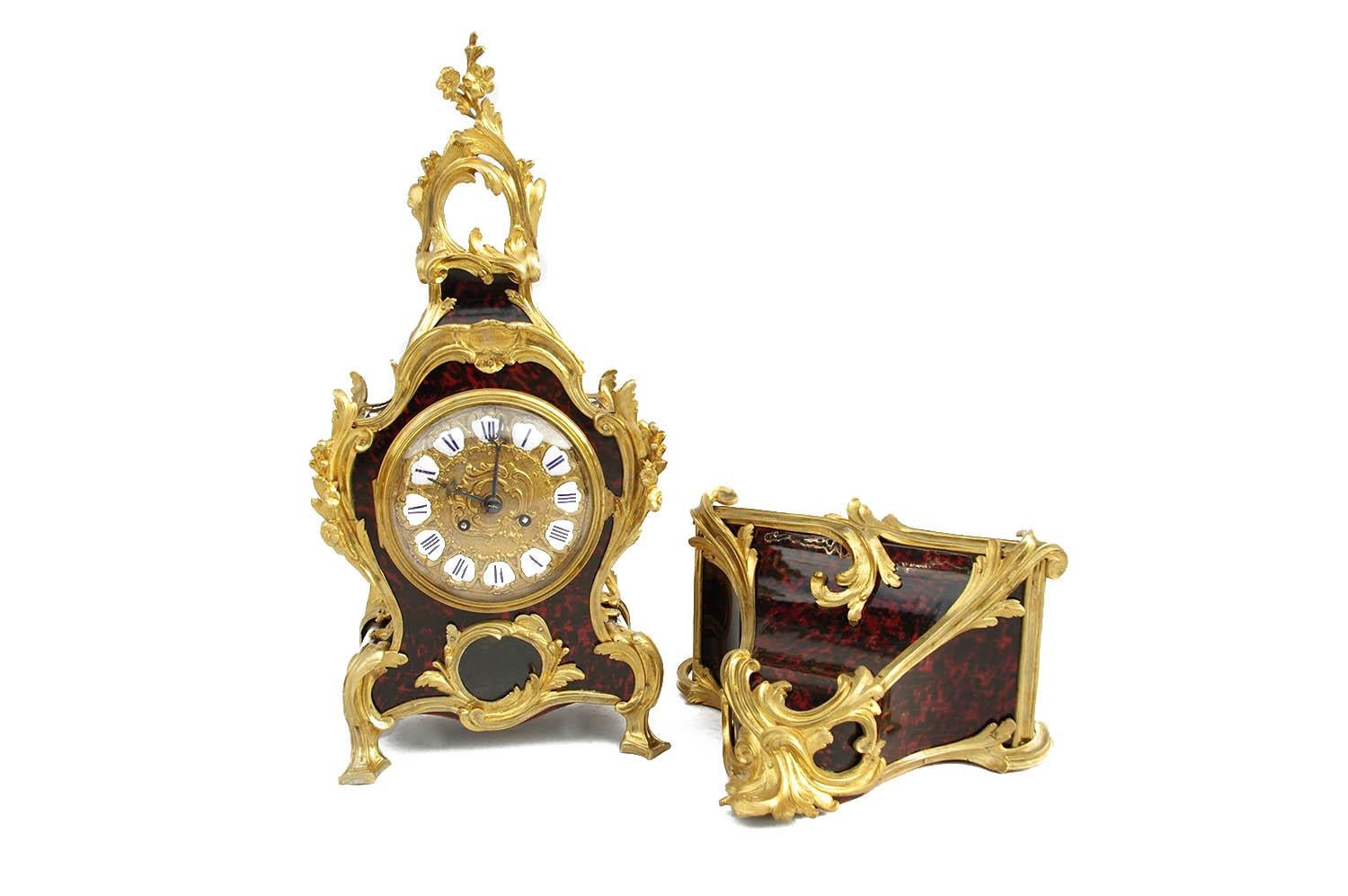 Louis XV style clock and its console in tortoise red scale and chiselled and gilt bronze.
Violin shaped clock standing on four gilt bronze legs and front adorned with a glazed cartouche permitting to see the pendulum. 
Rich chiselled and gilt