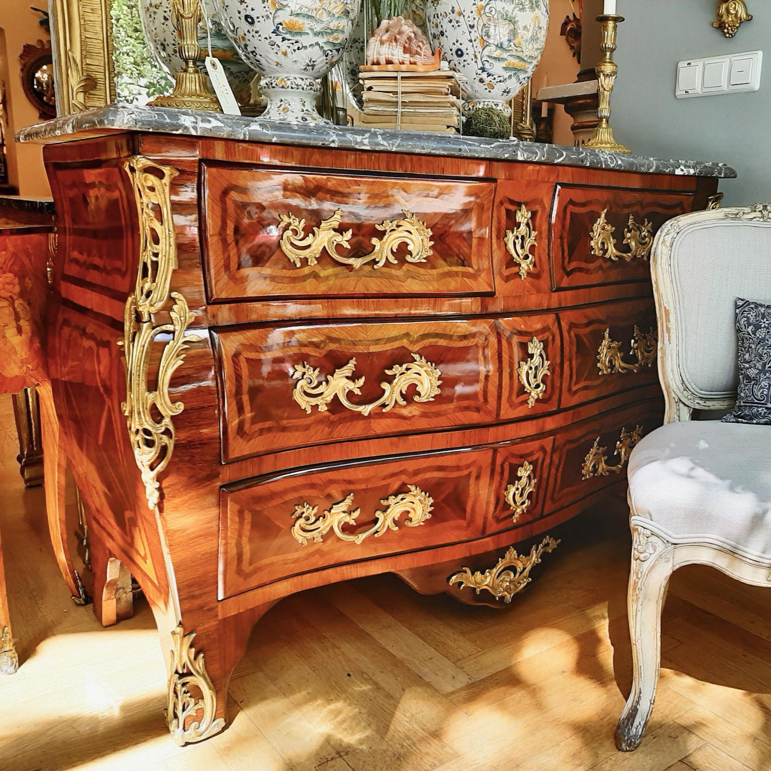 ! PLEASE NOTE: the French polish has recently been refreshed - the 2nd photo and following will give you the right impression of the surface - !
A Louis XV style marquetry commode or chest of drawers of tomb-shaped form, the serpentine top echoed by