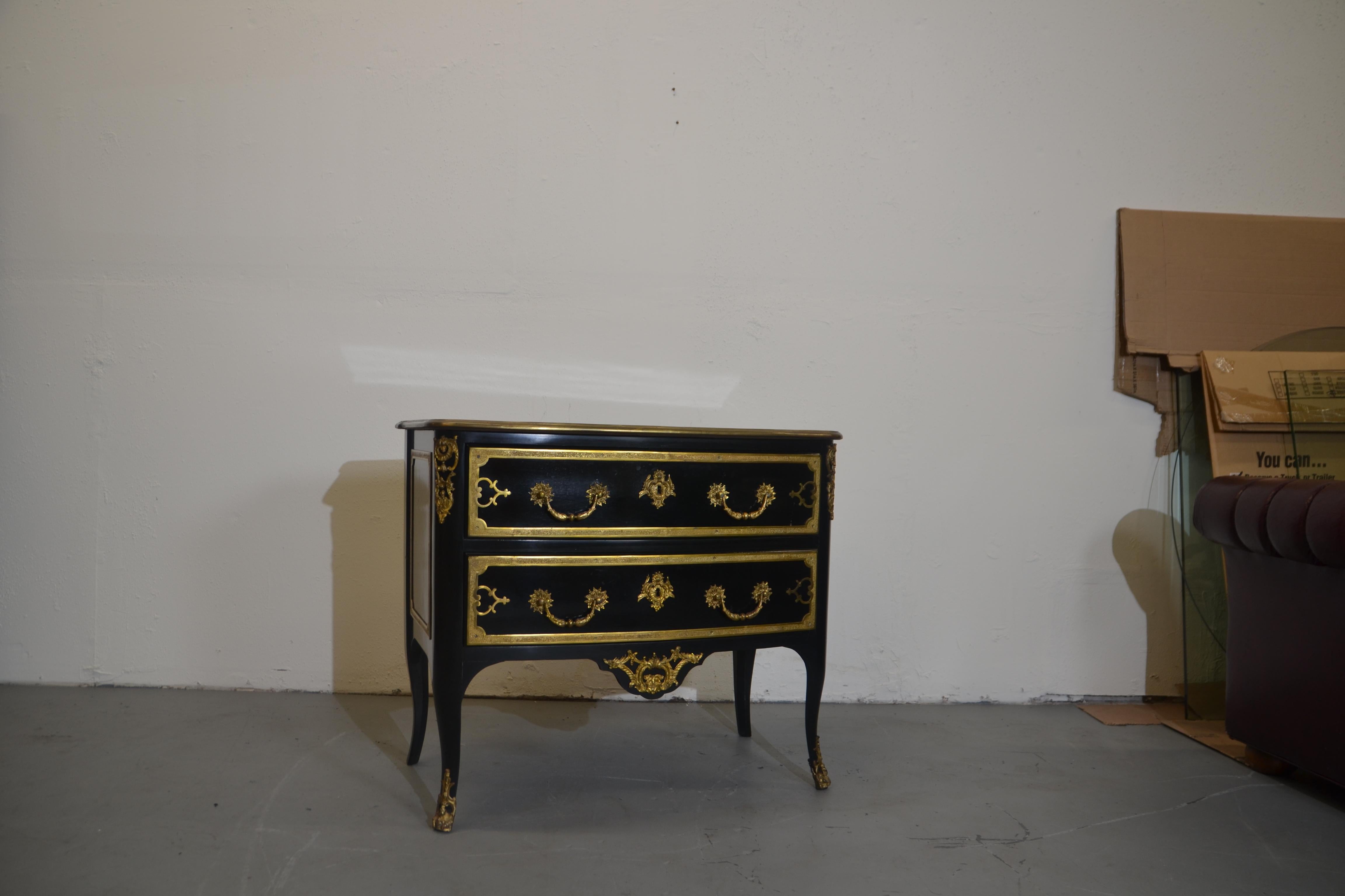 A French Commode Louis style XV. Ebonized finish and profusely decorated throughout with gilded decorations and ornate hardware.