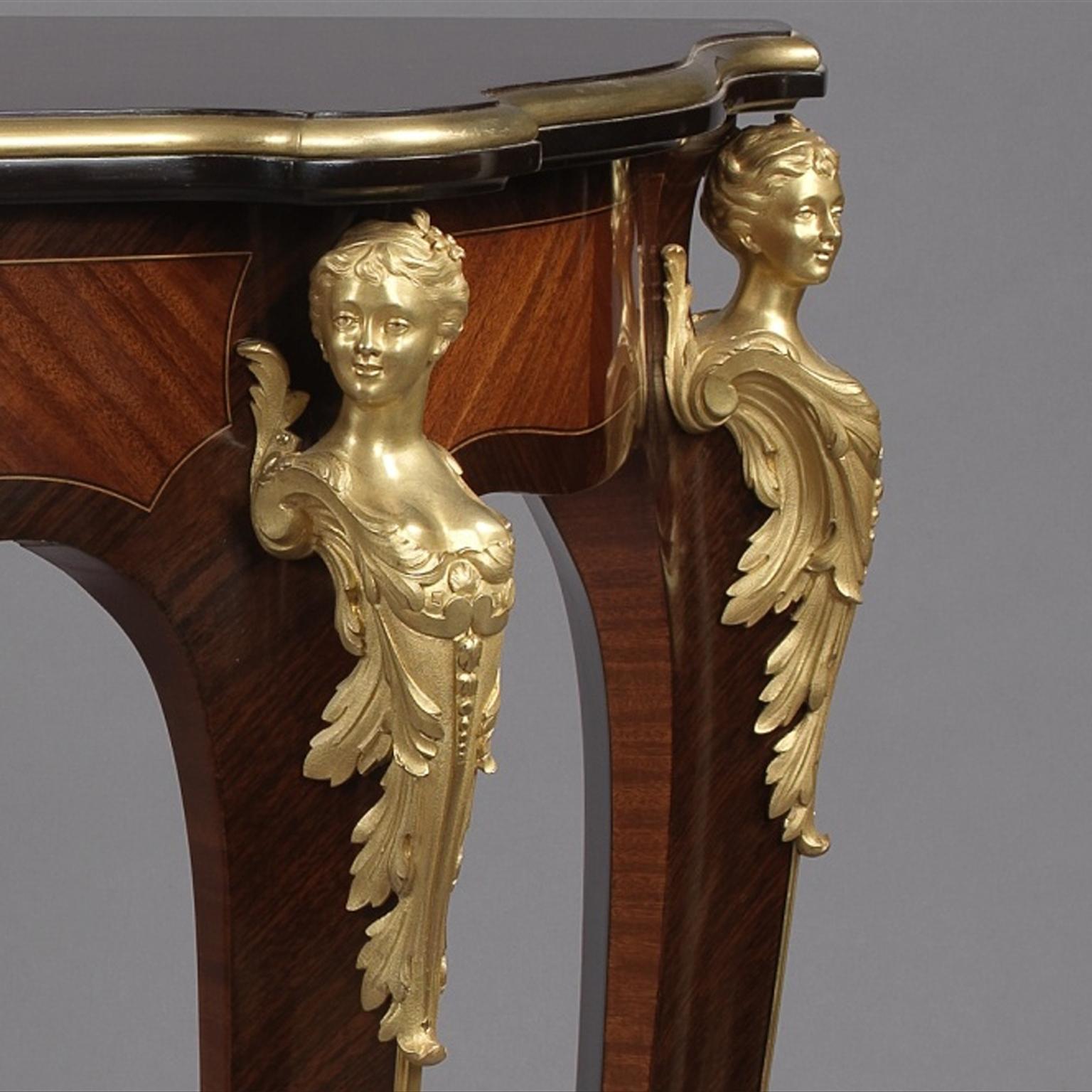 A fine Louis XV style gilt-bronze mounted console table, in the manner of François Linke.

This fine console table has a shaped top above a crossbanded frieze centred by a foliate gilt-bronze cartouche mount. The four cabriole legs are headed by
