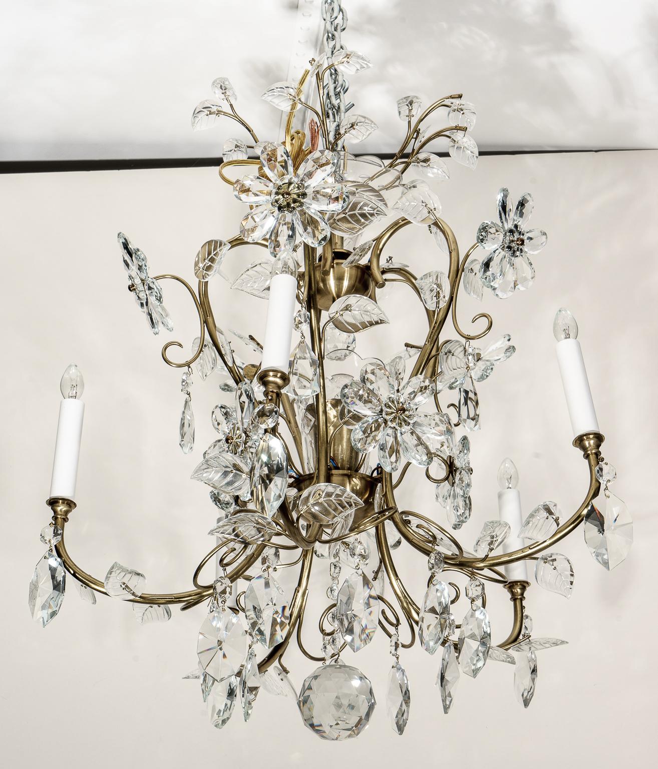Ce lustre élégant et romantique de style Louis XV est détaillé avec des fleurs et des feuillages stylisés en cristal.

Note : La hauteur sans la chaîne est de 25,50