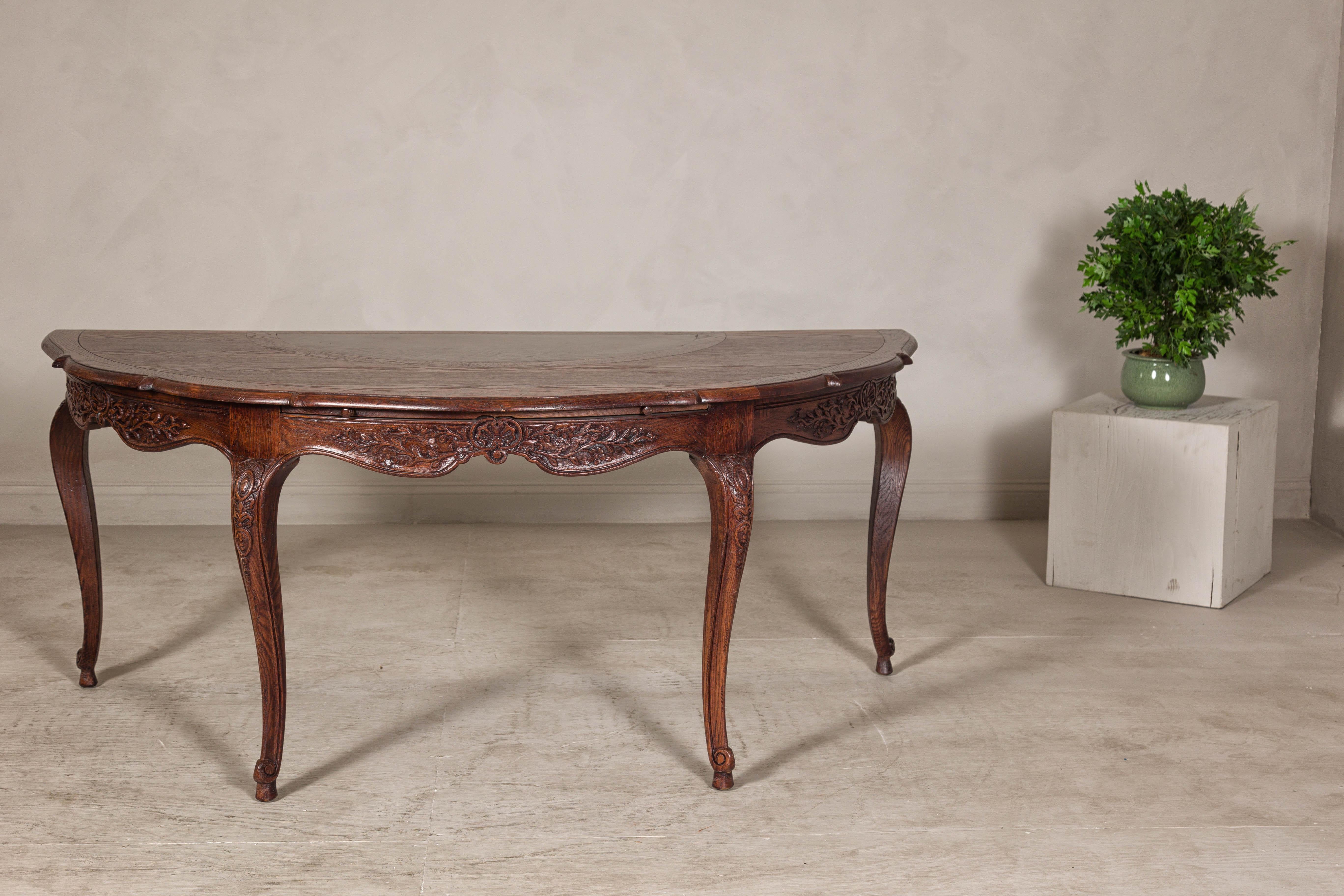This exquisite Louis XV-style demi-lune desk is a masterpiece of late 19th-century Dutch Colonial craftsmanship, defined by its elegant curves, intricate carvings, and luxurious materials. Crafted from rich hardwood with a deep patina that speaks to