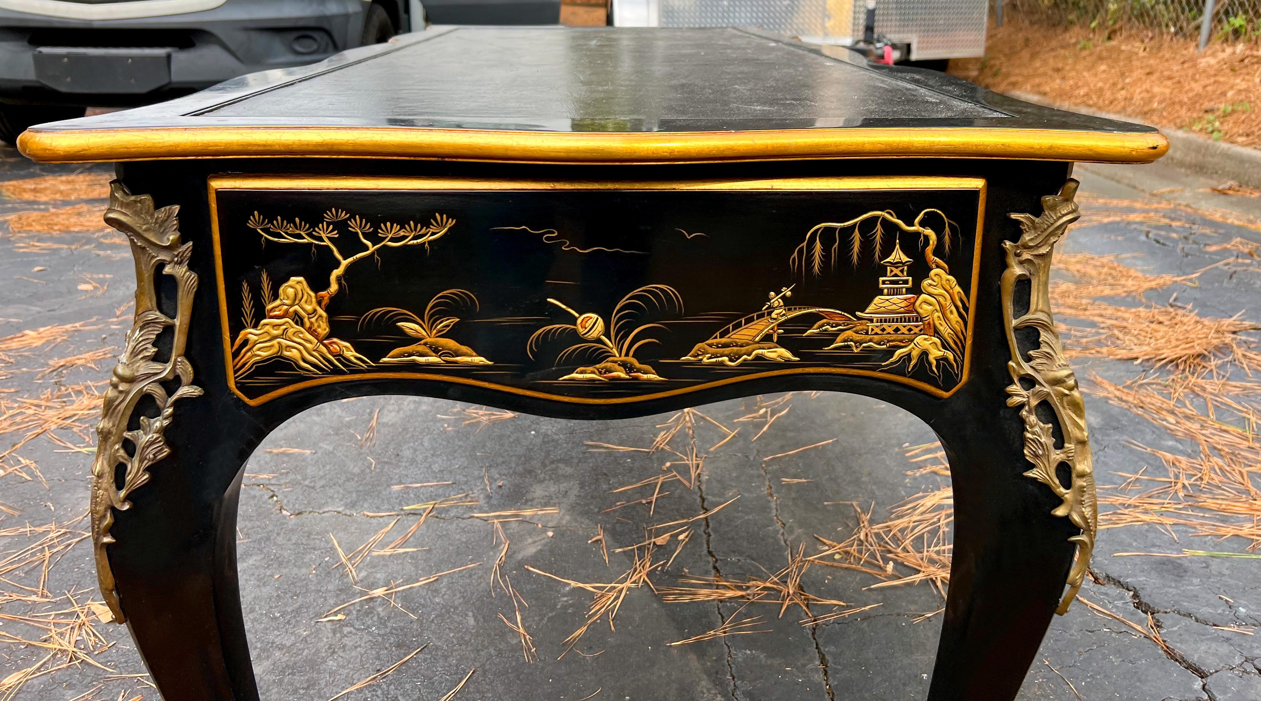 This is a special piece! This is a Louis XV style writing desk by Baker Furniture Co. it has a black leather top and bronze appointments. The chinoiserie pastoral scenes are on a black lacquer background. It is a purported to be a piece that was
