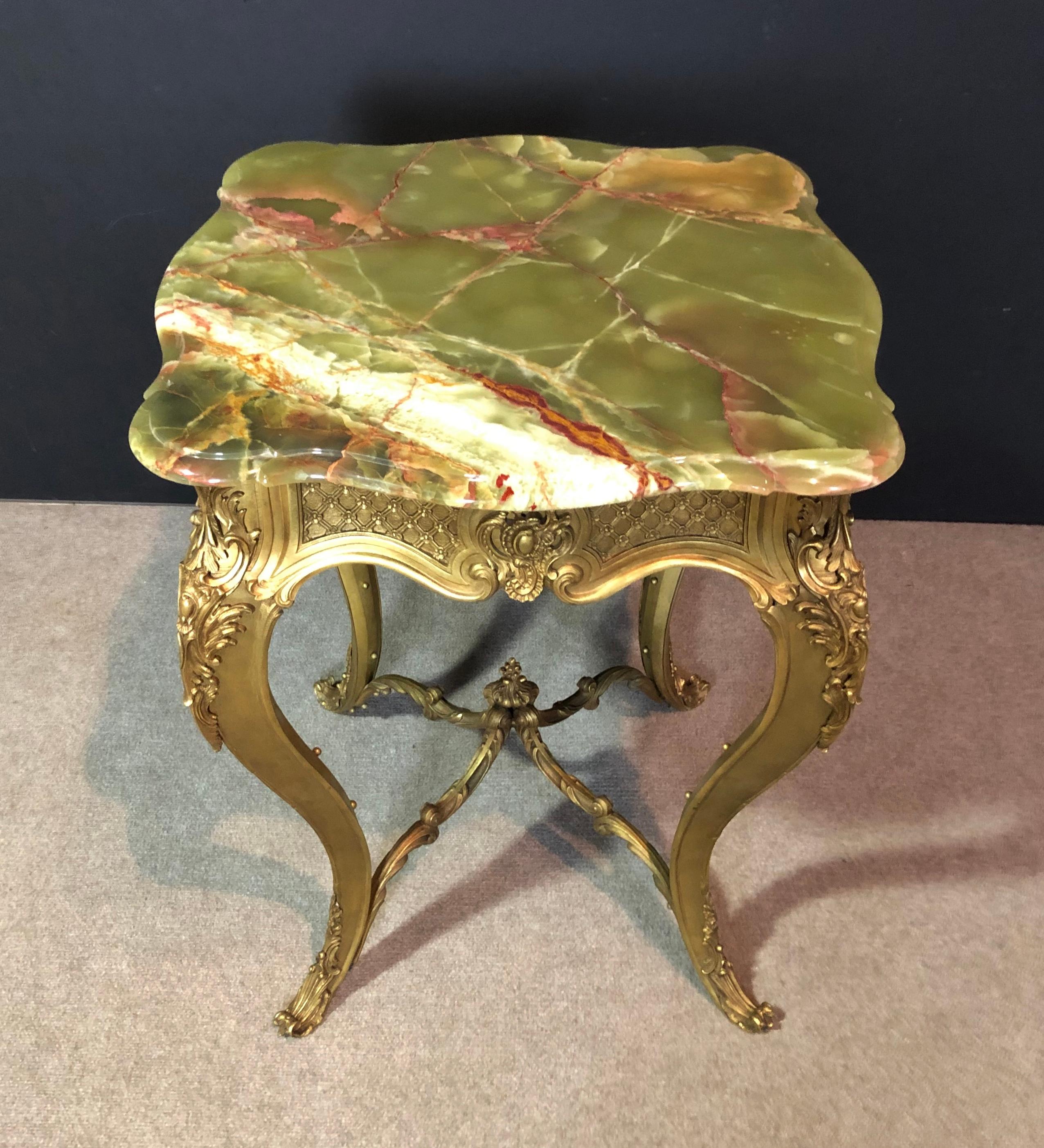 19th century Louis XV doré bronze and green onyx guéridon center table. Highly unusual and fine quality gilt bronze guéridon table with green onyx top. Rounded corners and scalloped sides. Nice ogee style edges to onyx. Some old repairs to onyx.