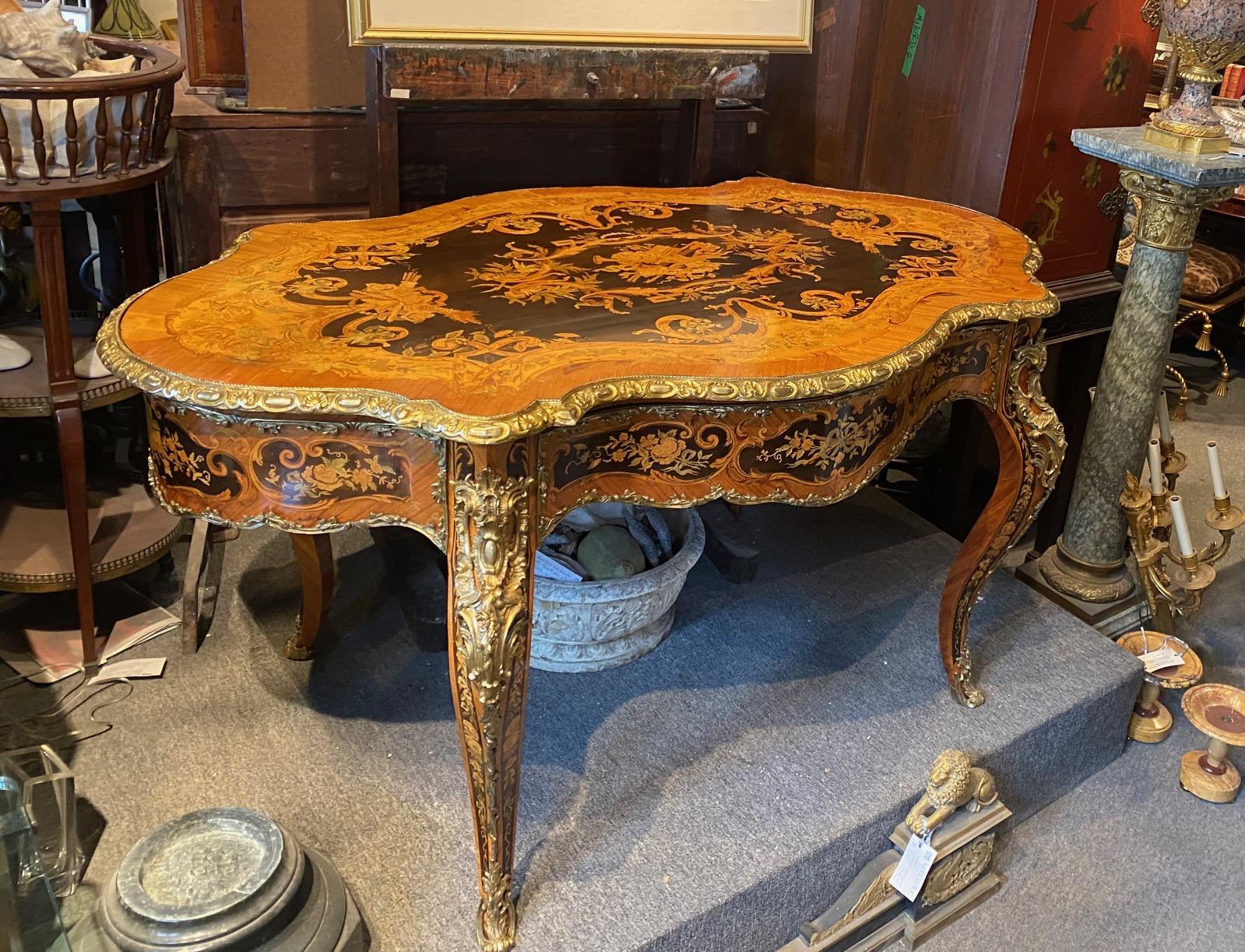 Louis XV Style Napoleon III period extensively inlaid marquetry center table in walnut, boxwood and  ebonized pearwood and sycomore fitted with gilt bronze mounts and central hidden drawer