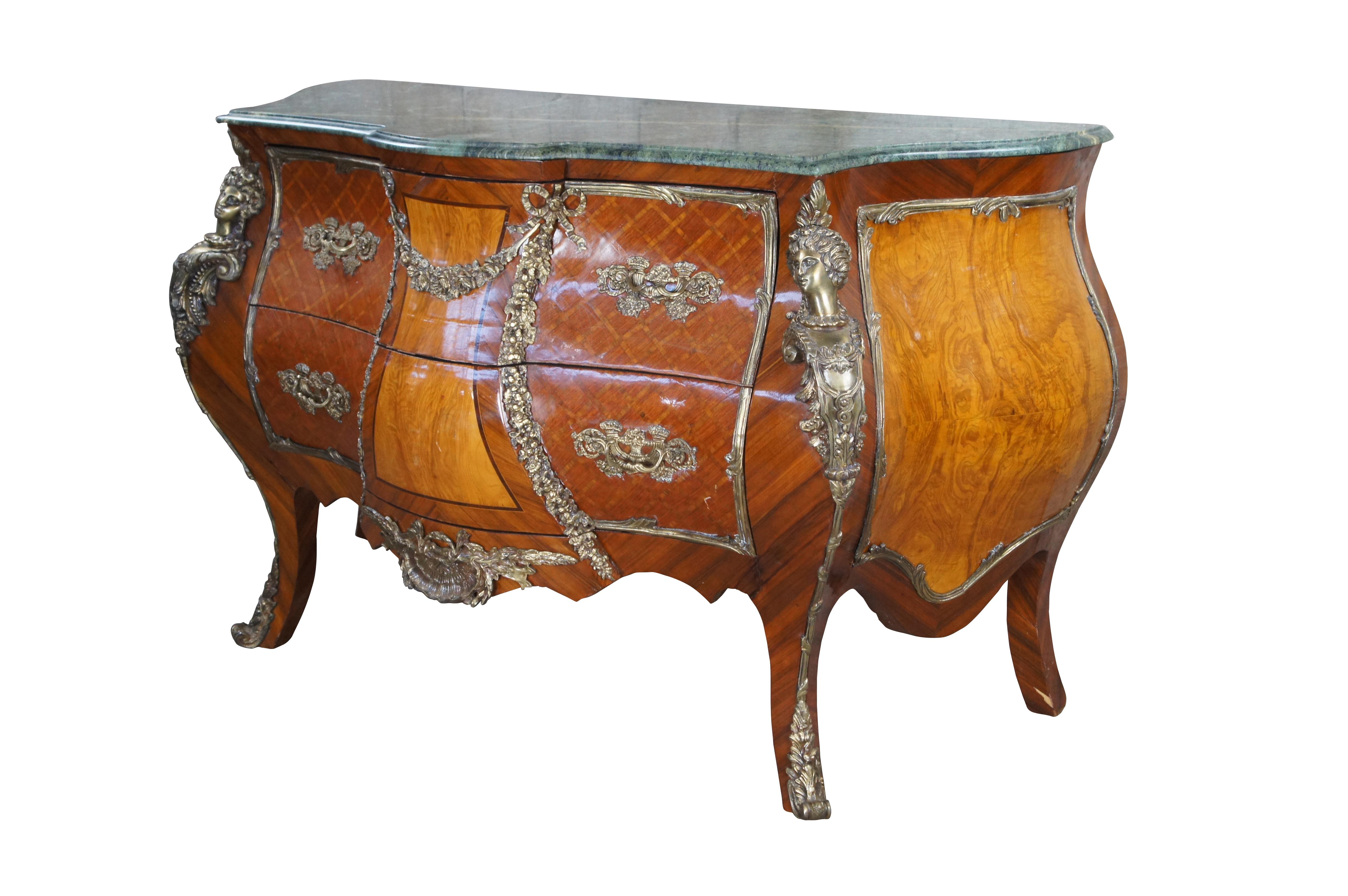 Una bellissima commode francese del XX secolo in stile Luigi XV. Realizzato in noce, ha una forma sagomata e presenta intarsi in parquet a reticolo, cariatidi figurate, fogliame in bronzo, volute e un piano in marmo verde. I lati e il pannello