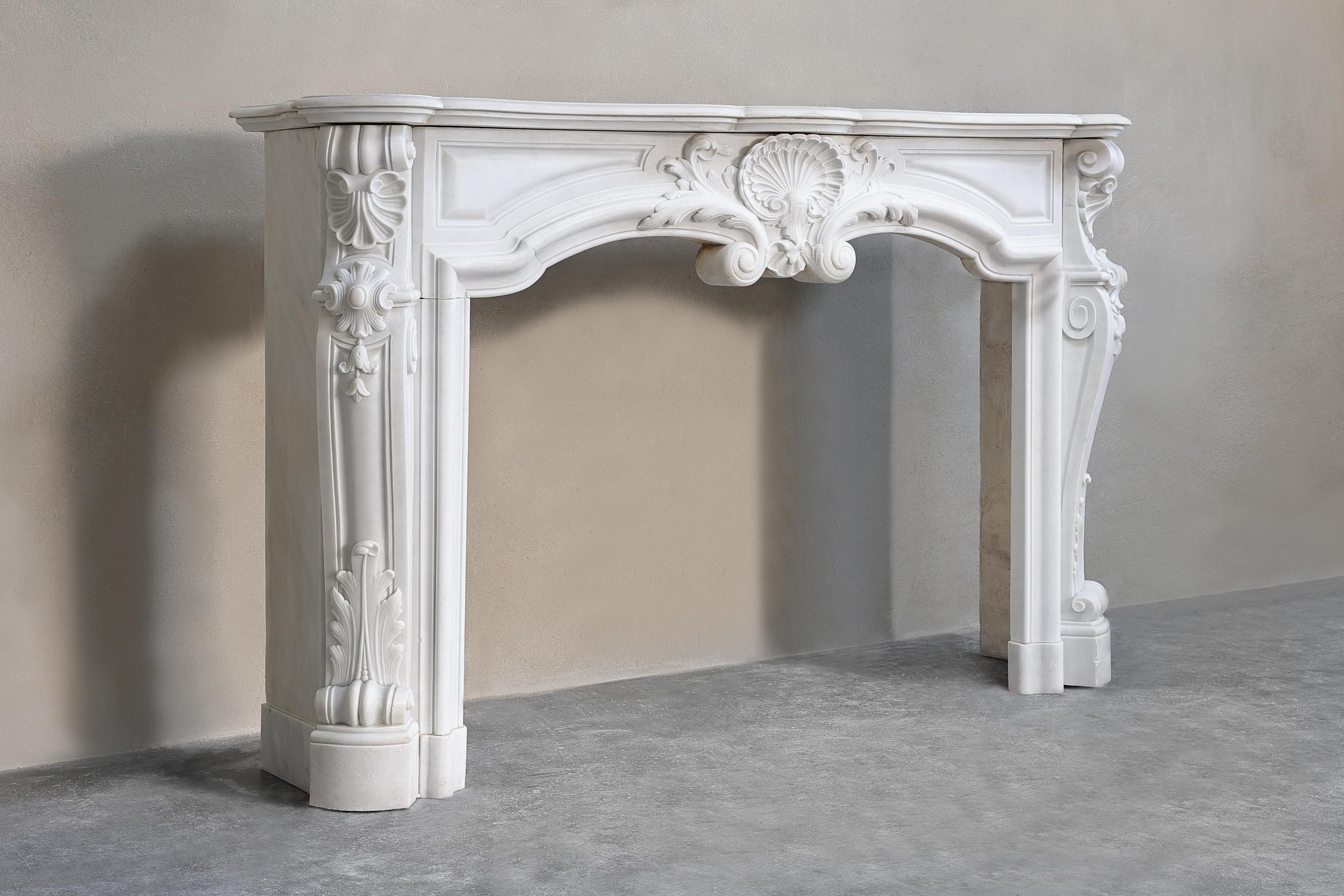 Beautiful elegant antique marble mantelpiece of Carrara marble in style of Louis XV with graceful elements such as a scallop in the middle of the front part and on the sides, acanthus leaves and beautiful lines. A very beautiful antique fireplace in