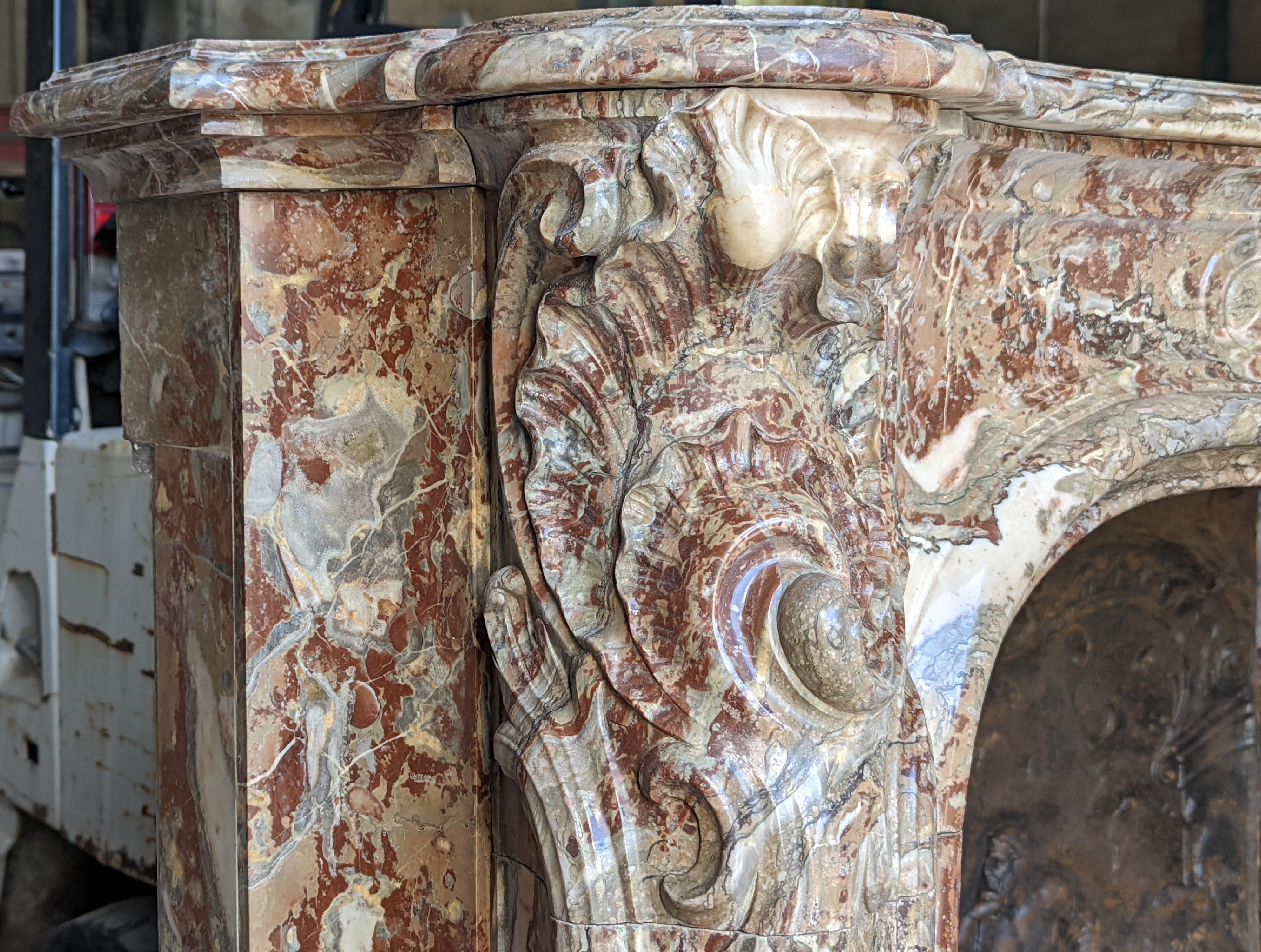 19th Century Louis XV style fireplace in Rouge Royal marble with an asymmetrical shell